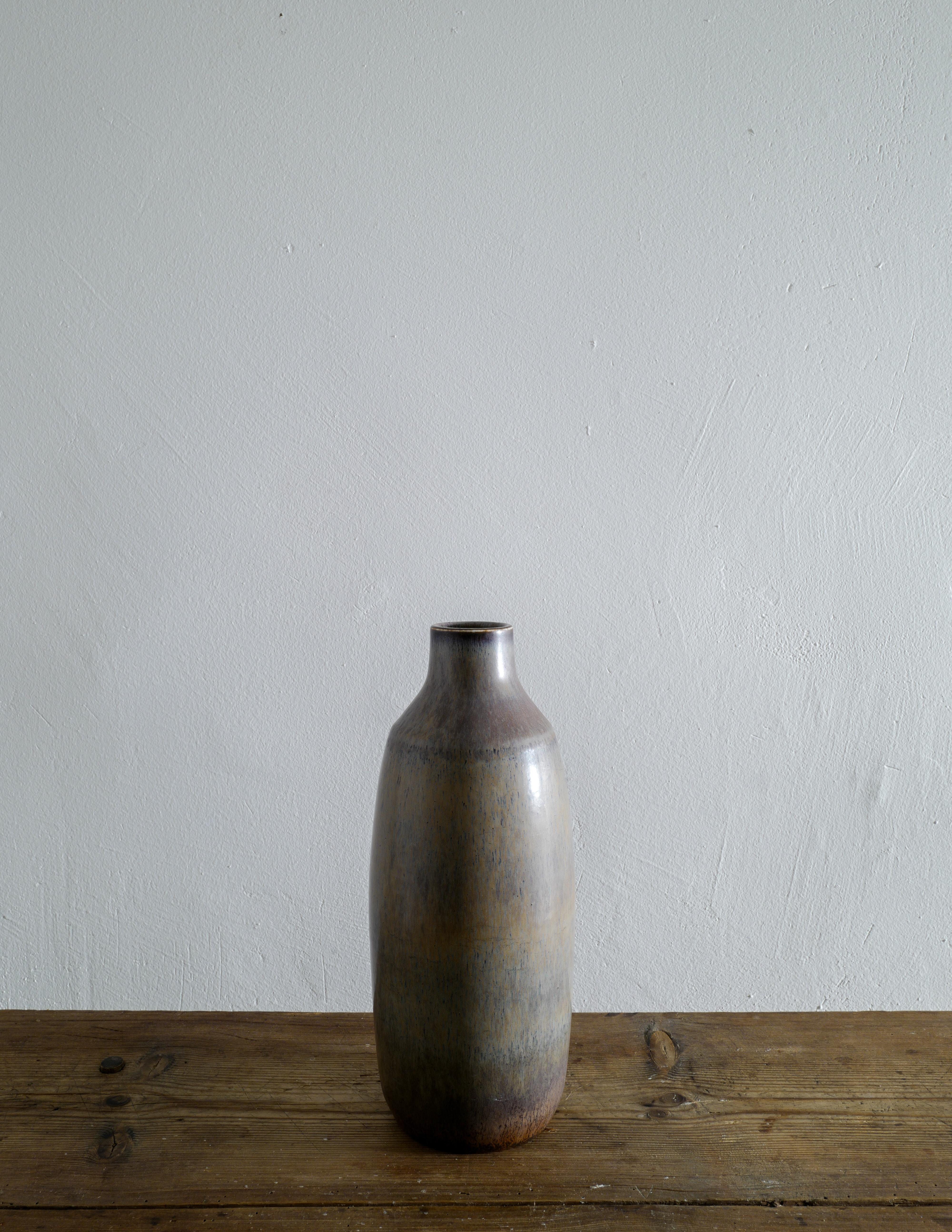 Seltene Carl-Harry Stålhane Vase in einer grau/braun/grünen Glasur in tollem Vintage-Zustand mit kleinen Alters- und Gebrauchsspuren. Hergestellt in Schweden für Rörstrand in den 1950er Jahren. Unterschrieben. 

Höhe: 34 cm 
Durchmesser: 14 cm