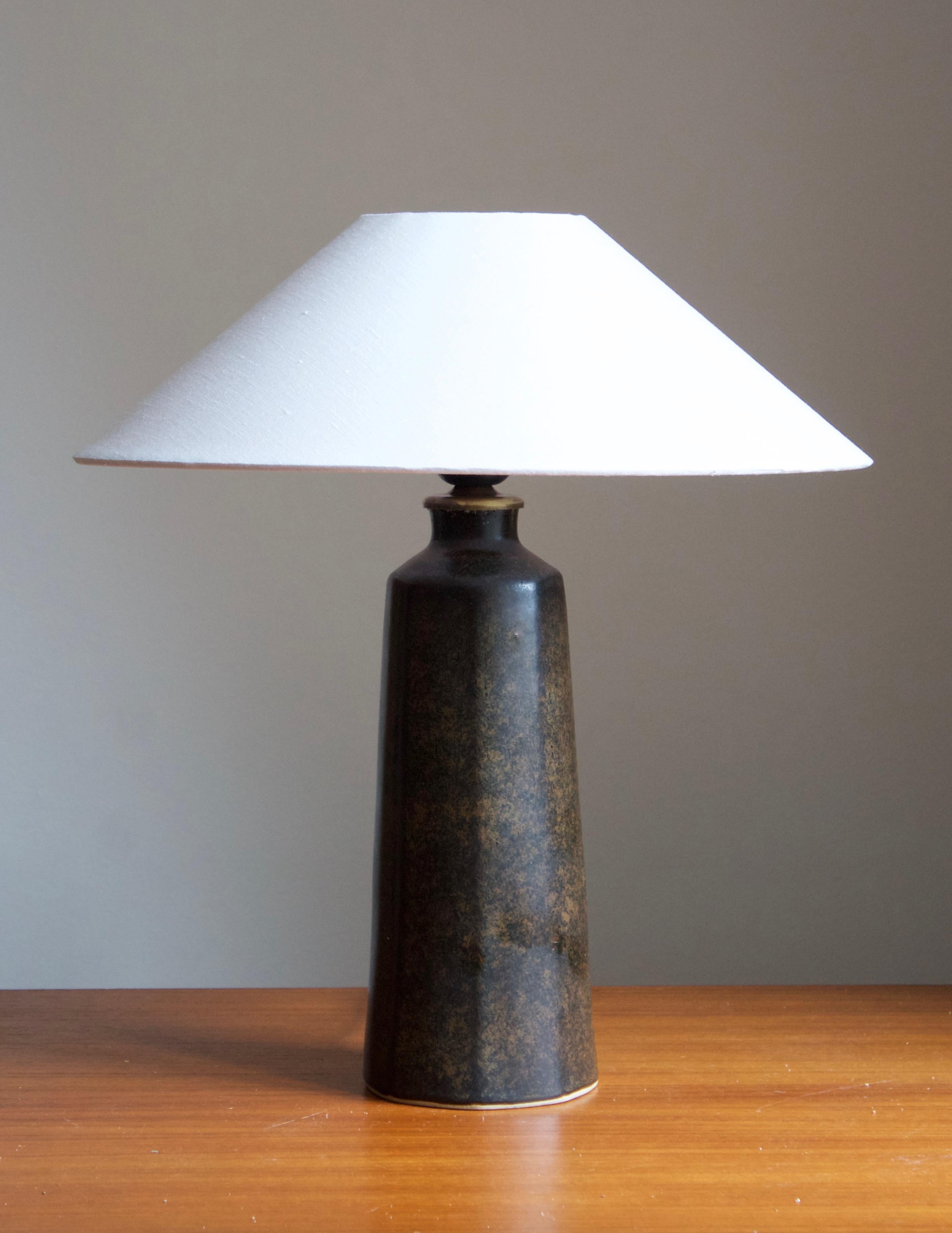 A table lamp by Carl-Harry Stålhane for the Swedish firm Rörstrand. 

Stated dimensions exclude lampshades. Height includes socket. Shade is not included in purchase.

Glaze features a brown-green color.

Other ceramicists of the period include
