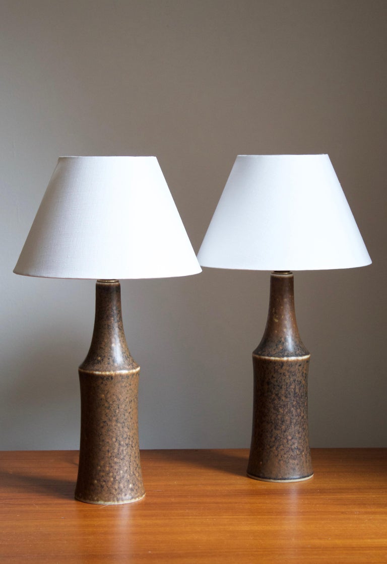 A pair of table lamps by Carl-Harry Stålhane for the iconic Swedish firm Rörstrand. Features highly artistic blue glaze.

Stated dimensions exclude lampshades. Height includes socket. Sold without lampshades.

Glaze features a brown color.

Other