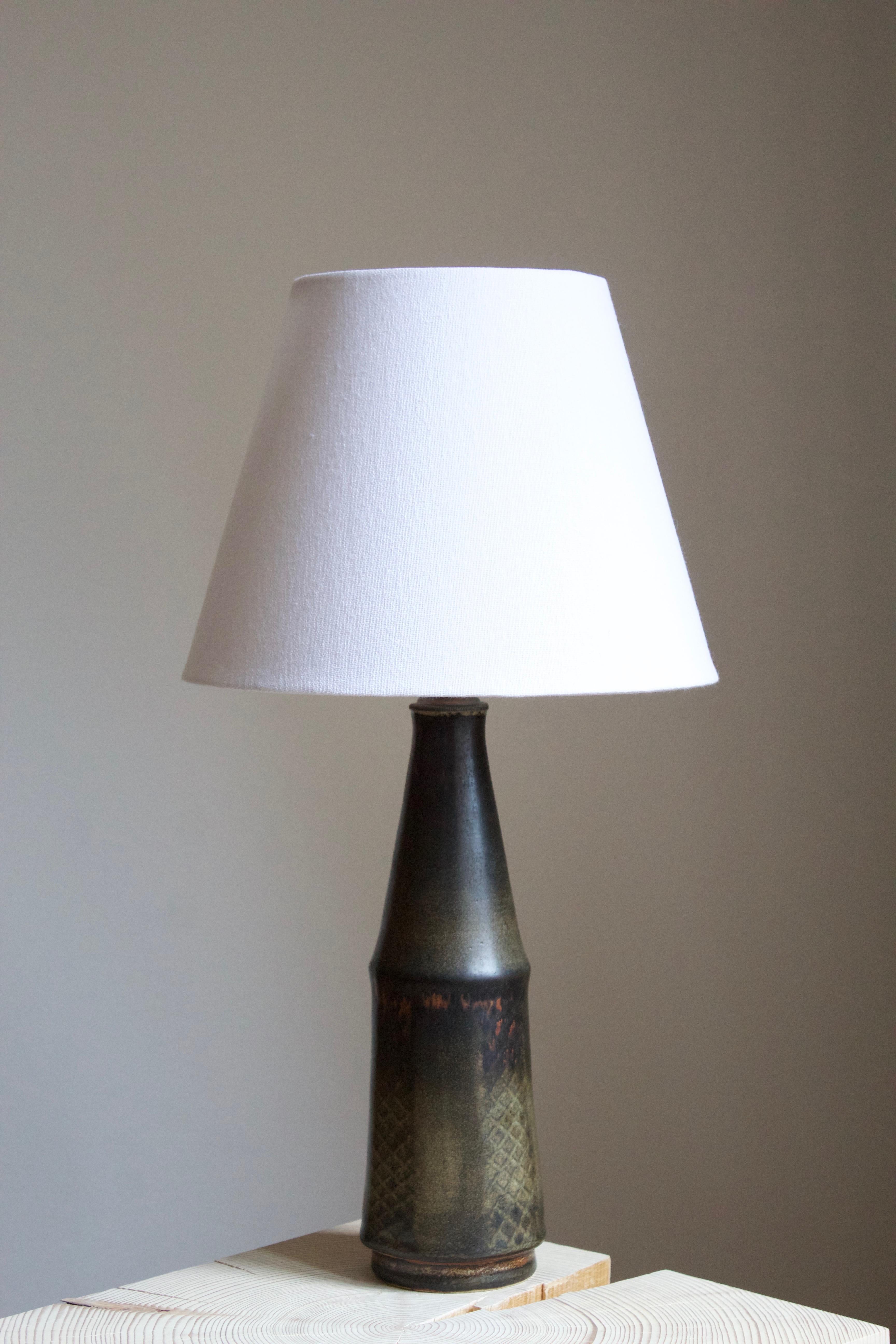 A unique table lamp by Carl-Harry Stålhane for the iconic Swedish firm Rörstrand. Signed. Features a complex and artistic glaze aswell as subtle incised decor.

Stated dimensions exclude lampshade. Height includes the socket. Sold without