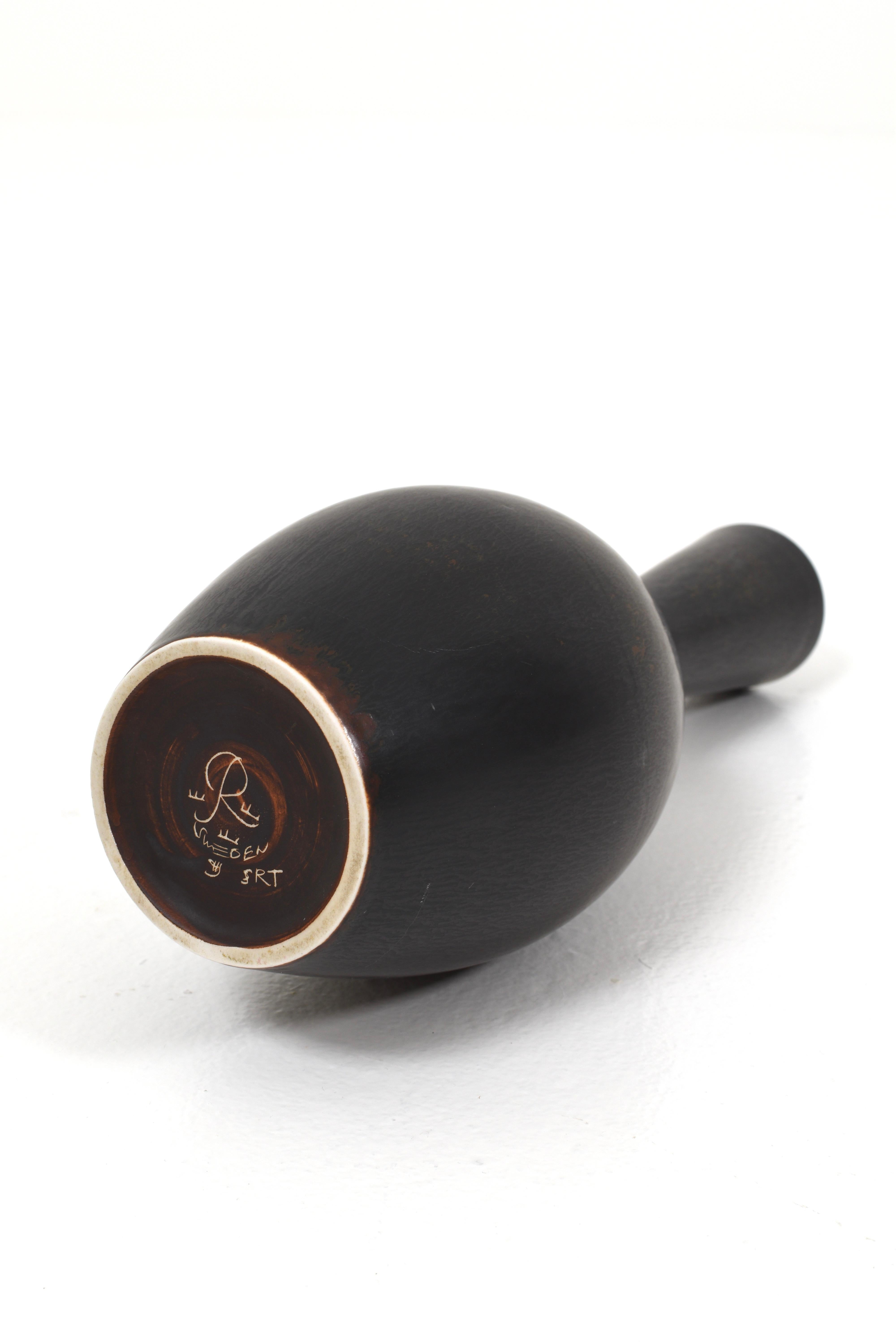 Très beau vase en céramique conçu par Carl-Harry Stålhane. Le vase a été fabriqué à Rörstrand, en Suède, dans les années 1950. Il est noir avec des touches de brun à certains endroits. 
Le vase est en parfait état vintage.