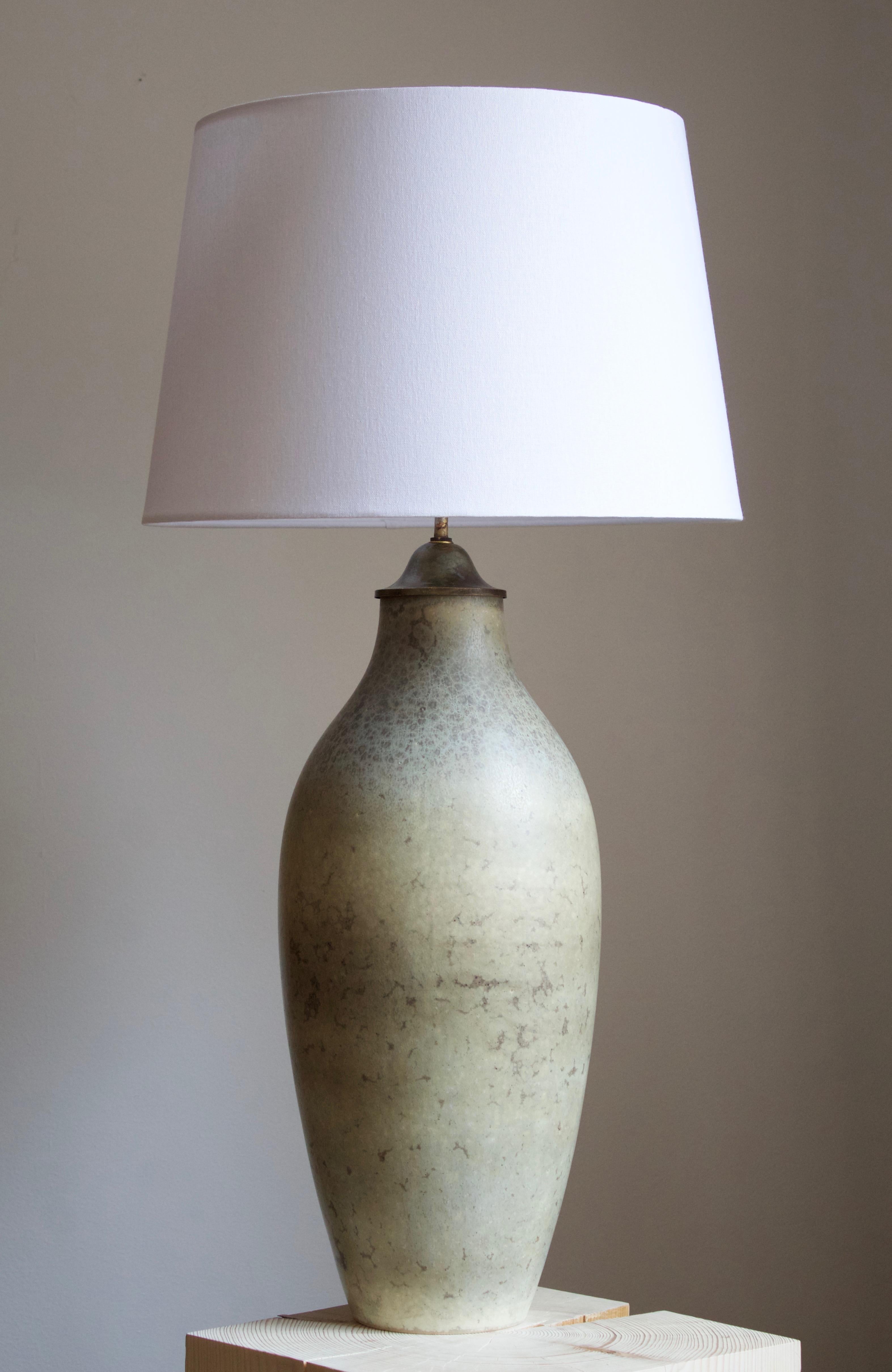 A table lamp by Carl-Harry Stålhane for the iconic Swedish firm Rörstrand. Signed.

Stated dimensions exclude lampshade. Height includes the socket. Sold without lampshade.

Glaze features a grey color with hints of brown.

Other ceramicists of the