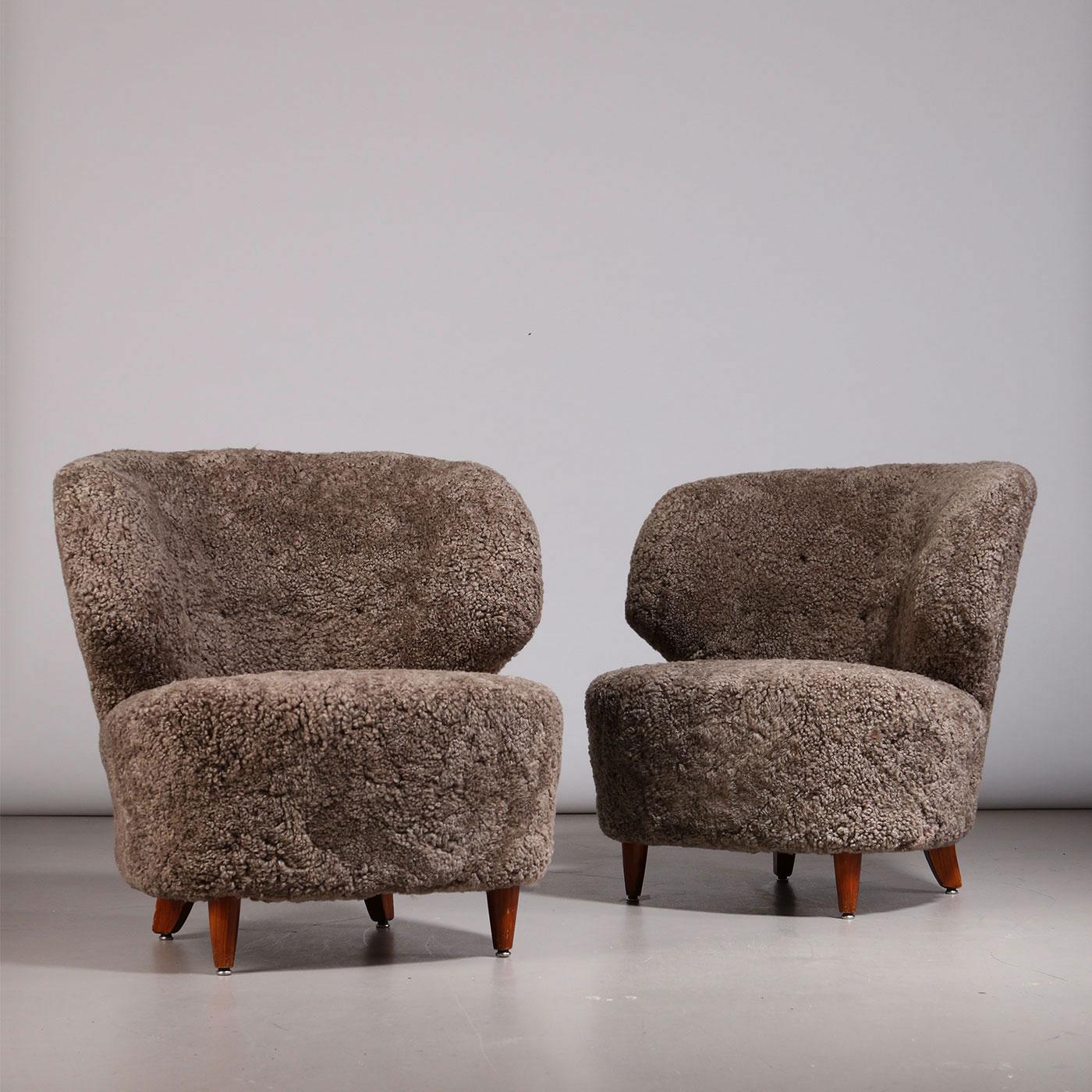 Pair of Finnish curved easy chairs, designed by Carl-Johan Boman. Produced by Oy Boman Ab in Finland, 1940s. Tapered wooden legs, seats are newly upholstered in Sahara sheepskin.

Please note that these easy chairs are also sold individually. Please