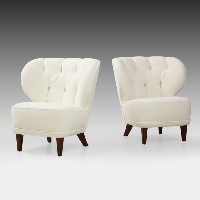 Carl-Johan Boman for Oy Boman AB rare pair of ivory velvet easy, lounge or slipper chairs with elegantly curved tufted backs and tapering stained maple legs, Finland, 1940s. These exquisite chairs have a classic Scandinavian Modern easy chair form
