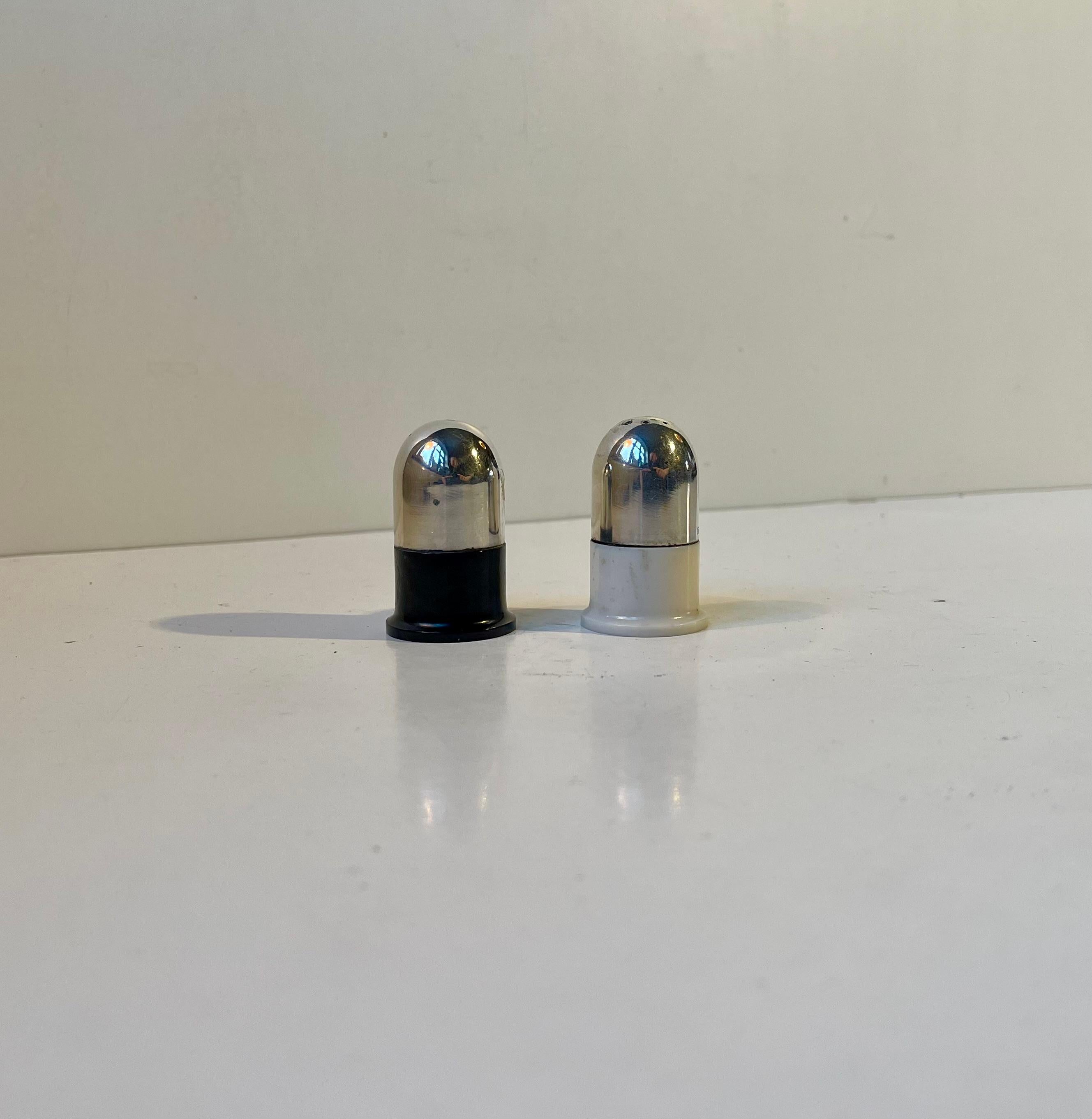 A small dinning table set of salt and pepper shakers. They feature a practical base of black and white bakelite and a top of 830/1000 silver. Both with Hallmark: CMC, 830s. In Denmark we call these salt & pepper robots,
They were made and designed