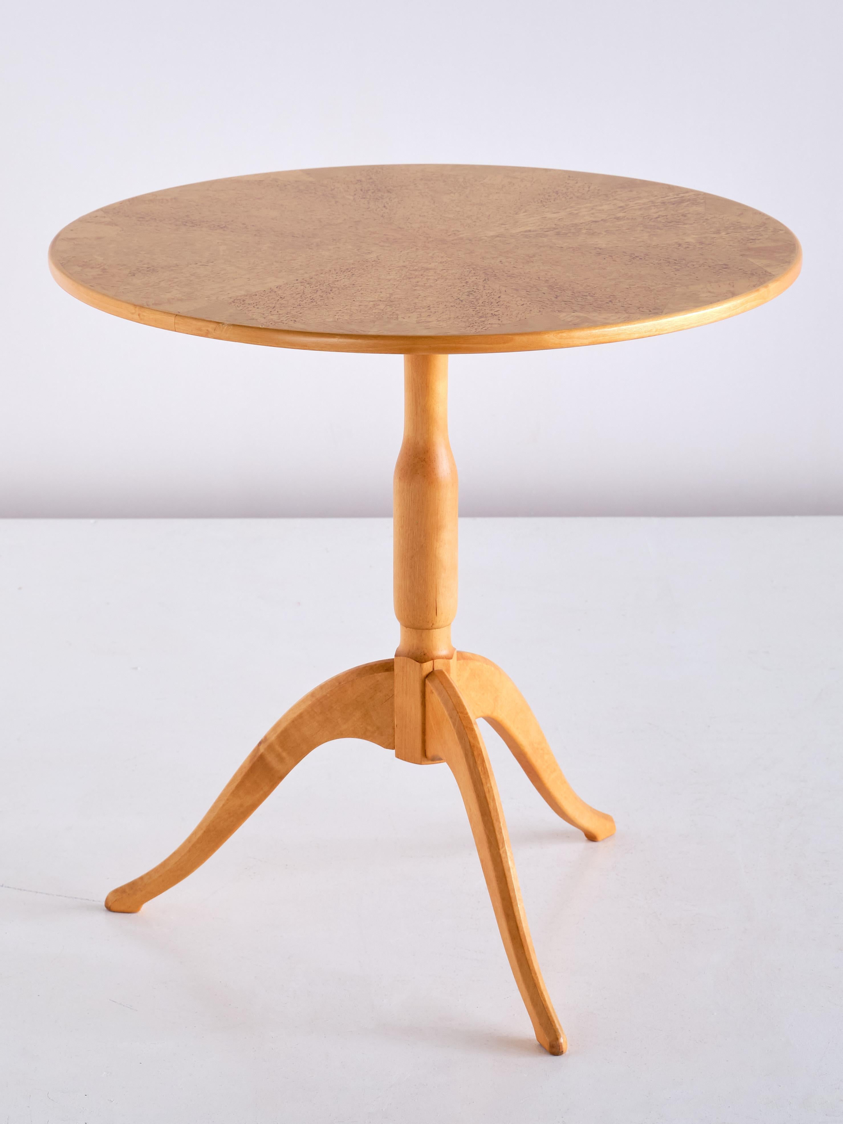 This elegant side table was designed by Carl Malmsten in 1936 as part of his 'Berg' series of three-legged tables. This example was produced by Carl Malmsten in the early 1950s. The round table has a top in a beautifully veneered Masur birch wood.