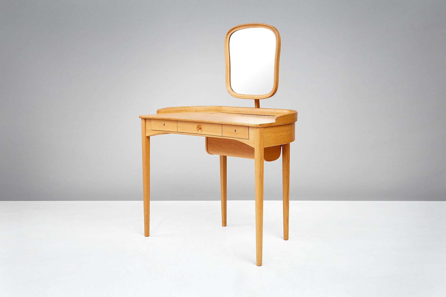Carl Malmsten

Birgitta dressing table, 1964

Exquisite dressing table produced by Bodafors, Sweden in oak. Adjustable mirror with brass fittings, 3 front drawers with original keys. Additional storage in desk top with tambour door. Rarely seen