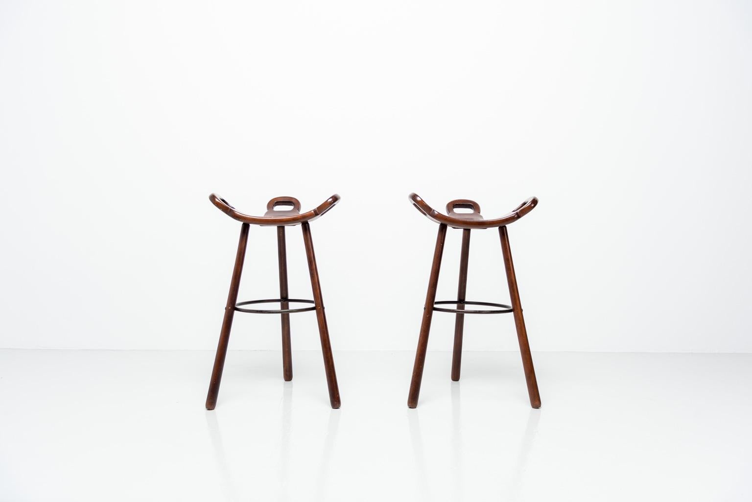 Very nice pair of bar stools designed by Carl Malmsten, Sweden 1950. These stools are very nicely shaped and made of solid birch wood, dark brown stained. The stools have a black metal supporting foot rest ring. These stools are in original