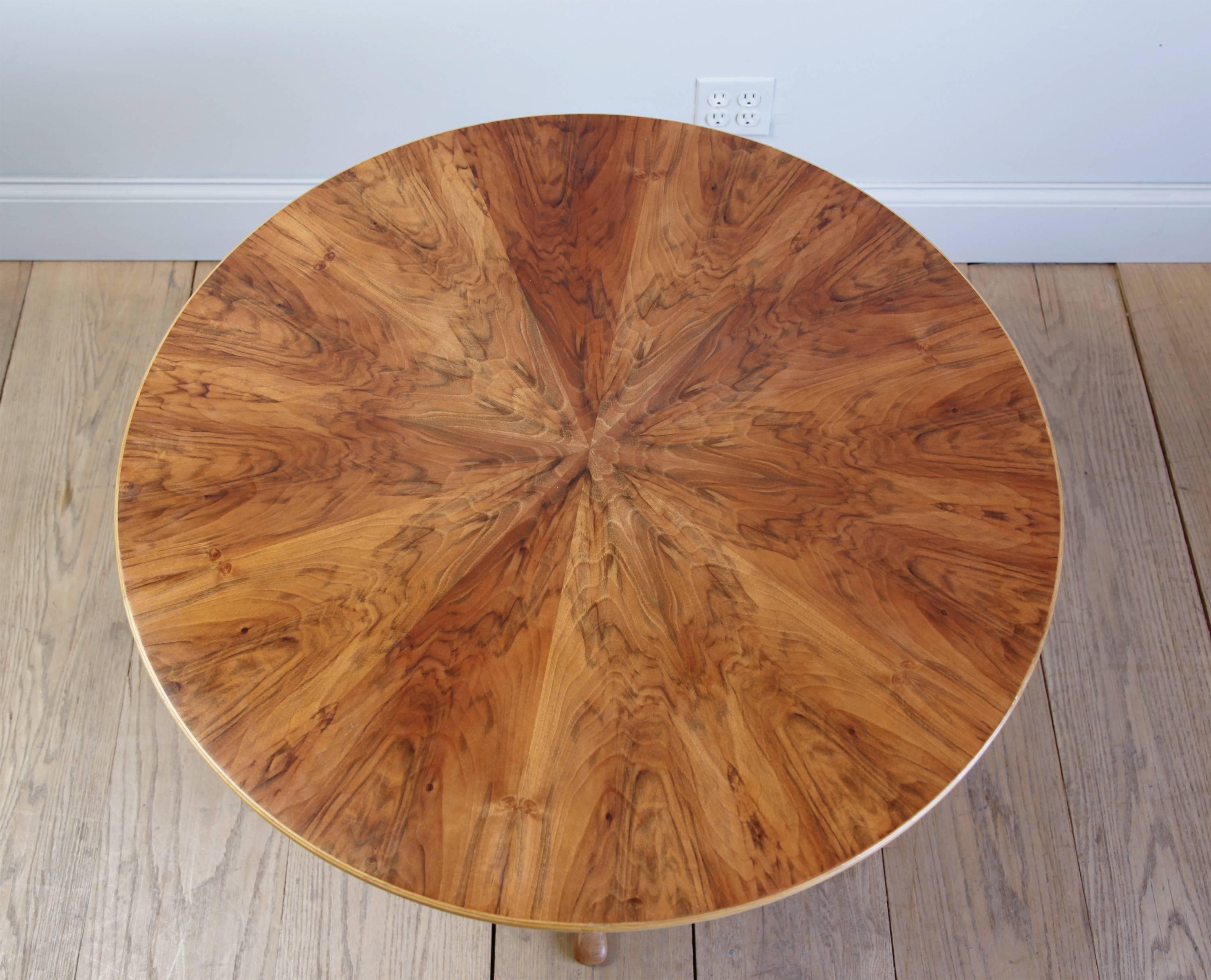 A graceful centre table, the top in radial bookmatched veneer, the tripod base of solid mahogany. Observe the subtle carving of the base, and the masterful joinery attaching the legs to the stem. Stamped CM. 

Carl Malmsten was one of the most