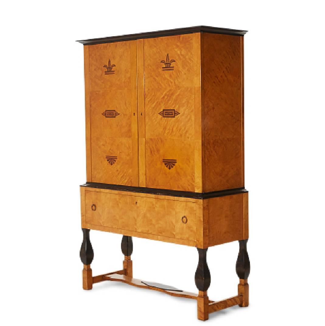 Cabinet from the “Haga” collection in birch with black intarsia decorations. Design by Carl Malmsten for Nordiska Kompaniet. Made in the 1920s. 
Dimensions: height 190, W126 x D48. Nordiska Kompaniet metal plate certifying the origin of manufacture.