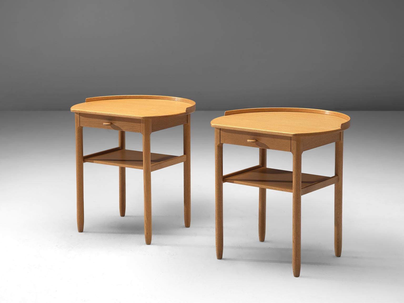 Carl Malmsten for Bodafors, pair of side tables, beech, Sweden, 1962.

This modest set of nightstands is designed by the Swede Carl Malmsten. The tables feature an underlying shelf and rail with small drawer. The drawers are finished with a