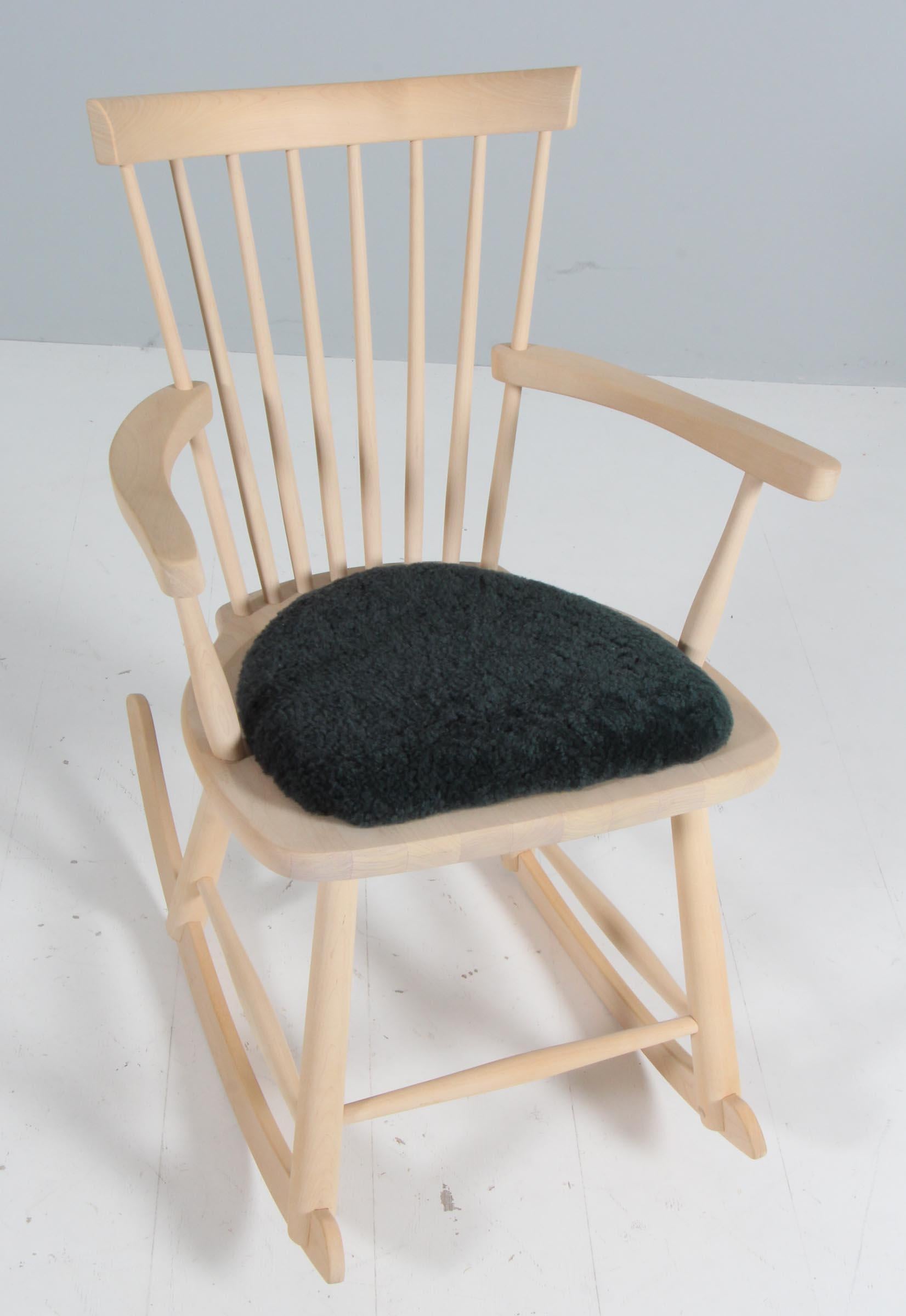 Fauteuil à bascule Carl Malmsten en bouleau massif. Avec coussin en peau d'agneau.

Modèle Lille Åland, fabriqué par Stolab