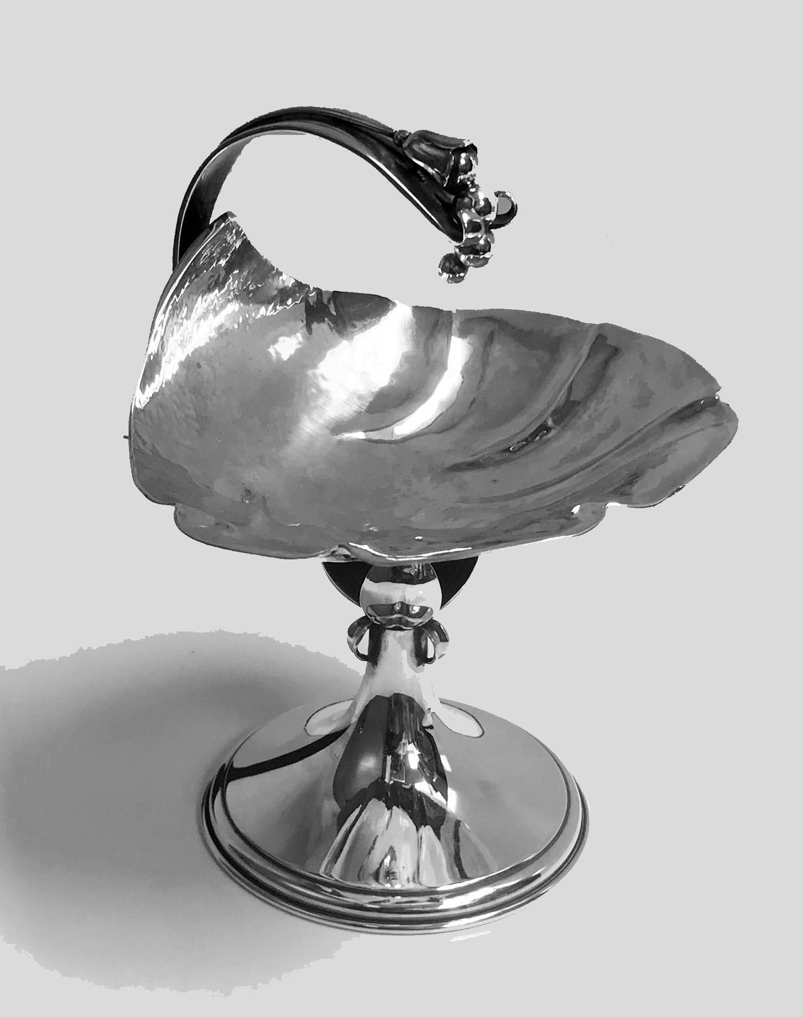 Carl Paul Petersen sterling silver compote, Montreal, circa 1940. In the style of Georg Jensen, with a leaf-shaped bowl hammered finish, curved handle terminating in bud leaf, supported by three open petals on a domed circular foot. Measures: Height