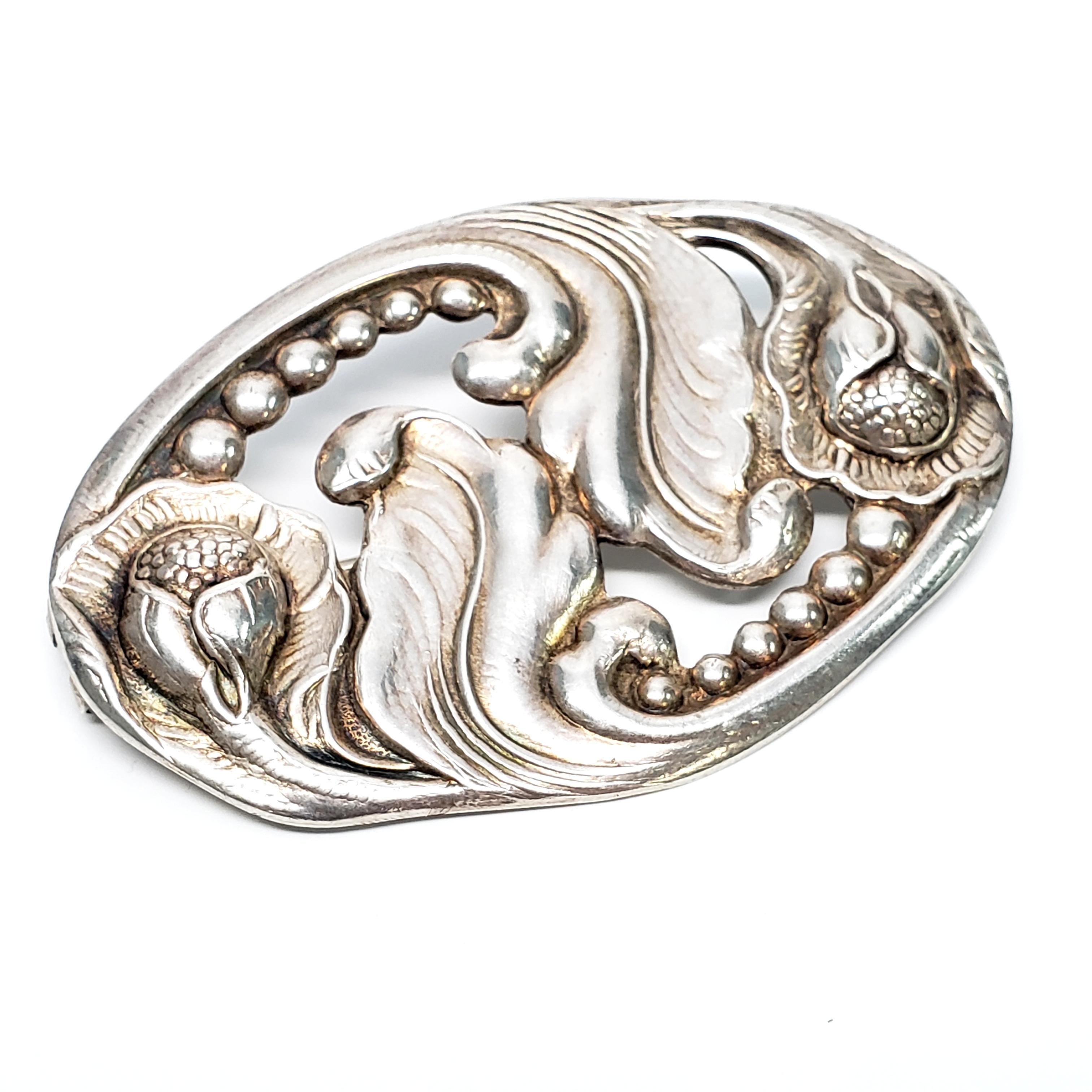 Vintage sterling silver floral oval pin/brooch by Carl Poul Petersen.

Carl Poul Petersen apprenticed under Georg Jensen from 1908-1913. The pin features a leafy floral motif with beaded accents.

Measures 2 1/2