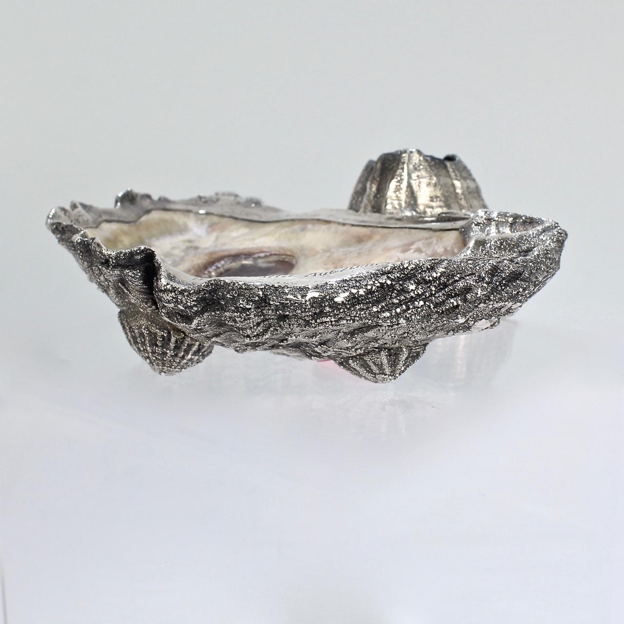 An antique Carl Schon oyster shell & sterling silver ashtray with an integral barnacle match holder and shell feet.

The ashtray is dedicated as yachting trophy for the Atlantic Yacht Club. 

(Apparently a winning captain could sometimes chose the