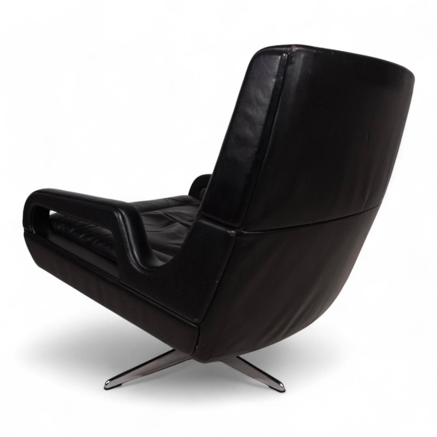 Cette chaise longue noire, conçue et produite par Carl Straub dans les années 1960, est en excellent état. Le cuir noir profond ne présente qu'une légère patine sur le dossier et les côtés. Les coussins d'assise et de dossier ne présentent