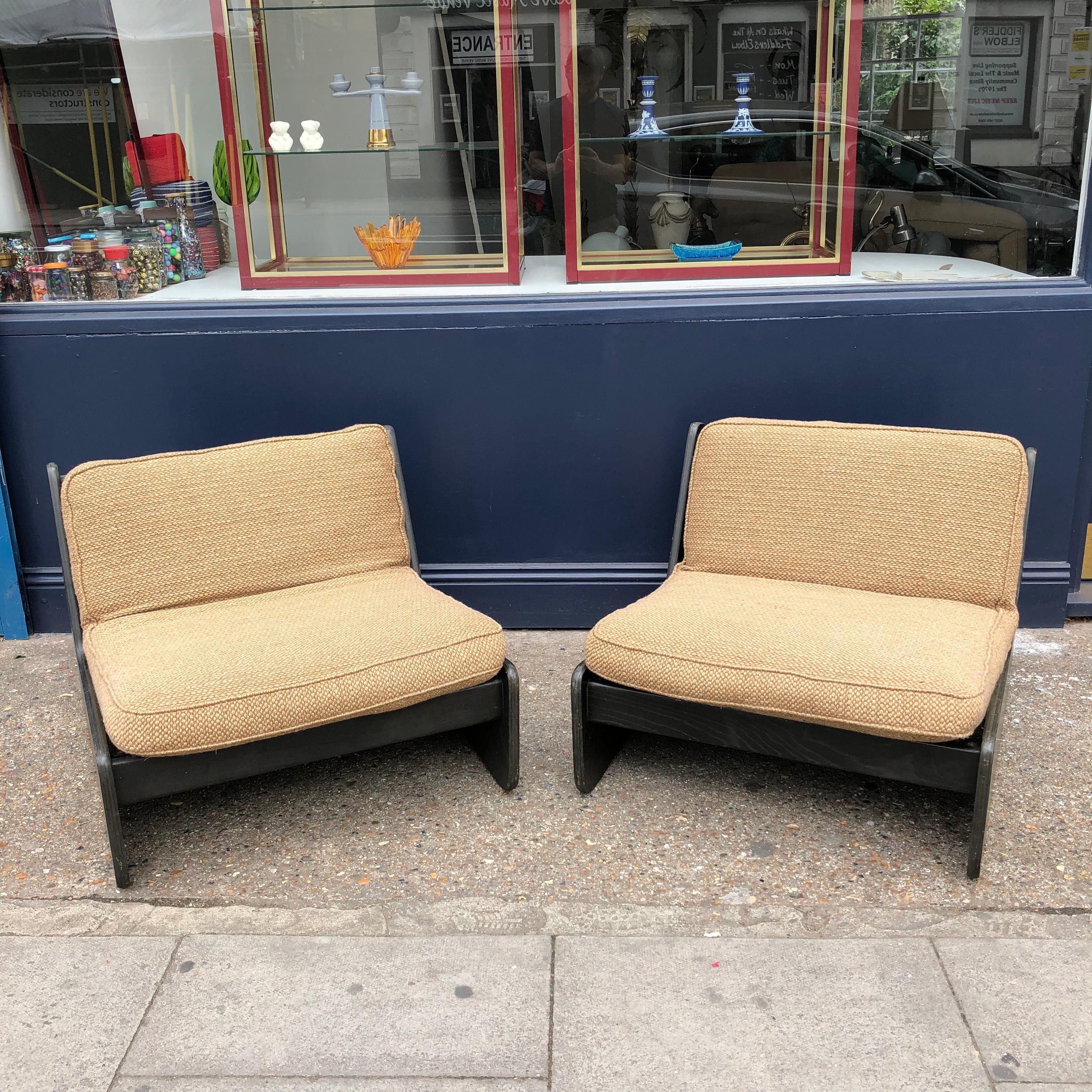 A gorgeous pair of wood and boucle fabric lounge armchairs by Carl Straub, that can combine to form a modular sofa. Supremely comfortable, and with a sleek low seat and back, these chairs would be ideal for any interior due to their versatility and