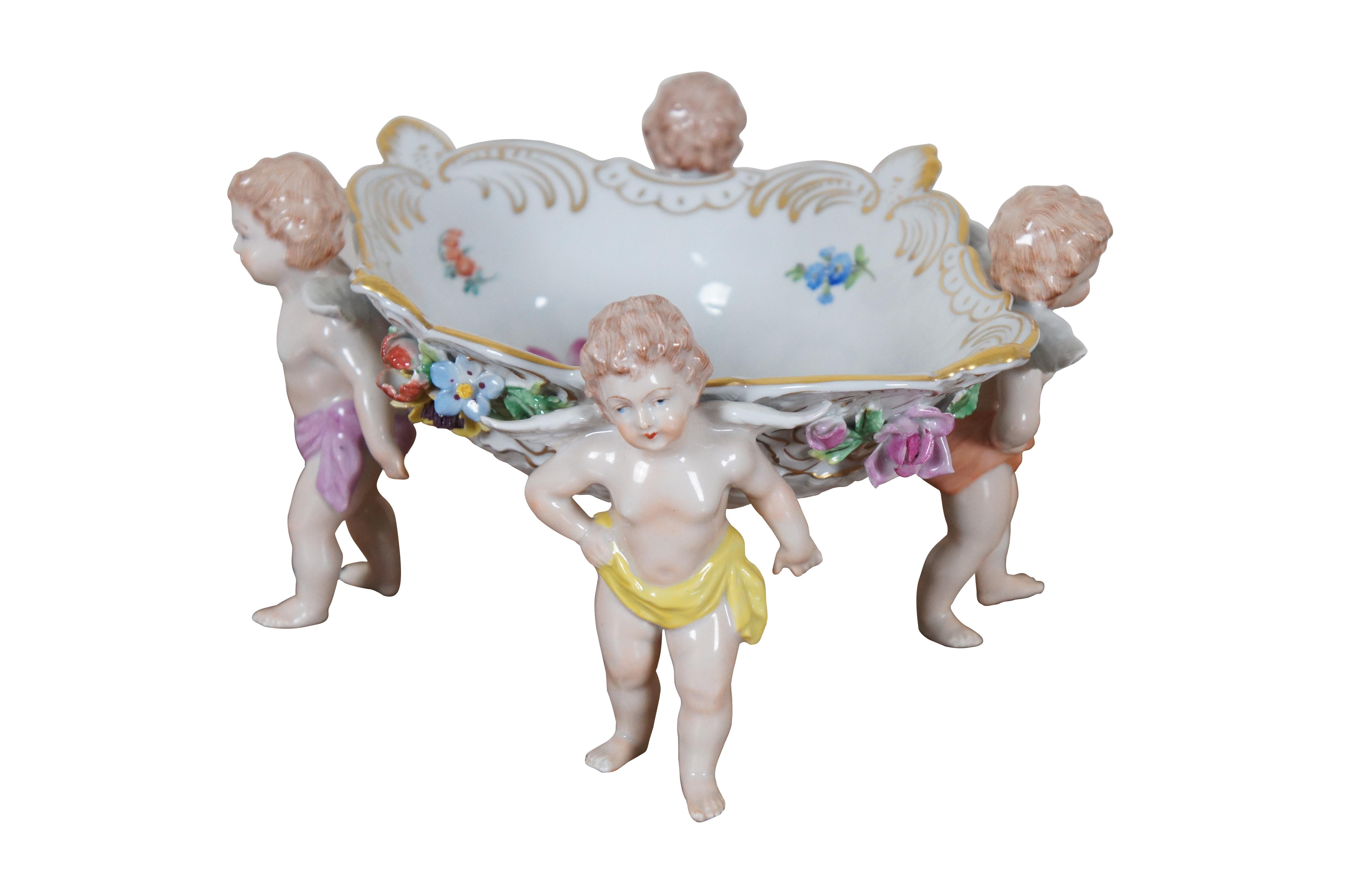 An exceptional Carl Thieme for Dresden Polychrome Centerpiece. Made from porcelain with colorful details.  The bowl has a diamond form with flowers and gold trim. Supported by four cherubs / Puttis.  

“The Sächsische Porzellan-Manufaktur Dresden