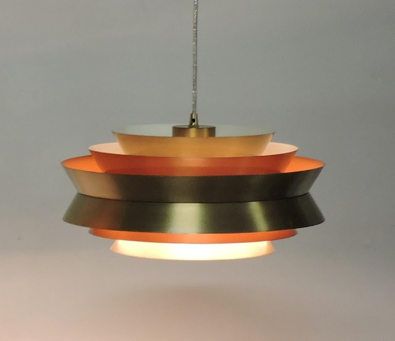 Beautiful Trava pendant light designed by Carl Thore and made in Sweden by Granhaga Metallindustri. This light has six aluminum shades with a brushed brass finish on the outside and white and orange on the inside, which makes for a beautiful glow