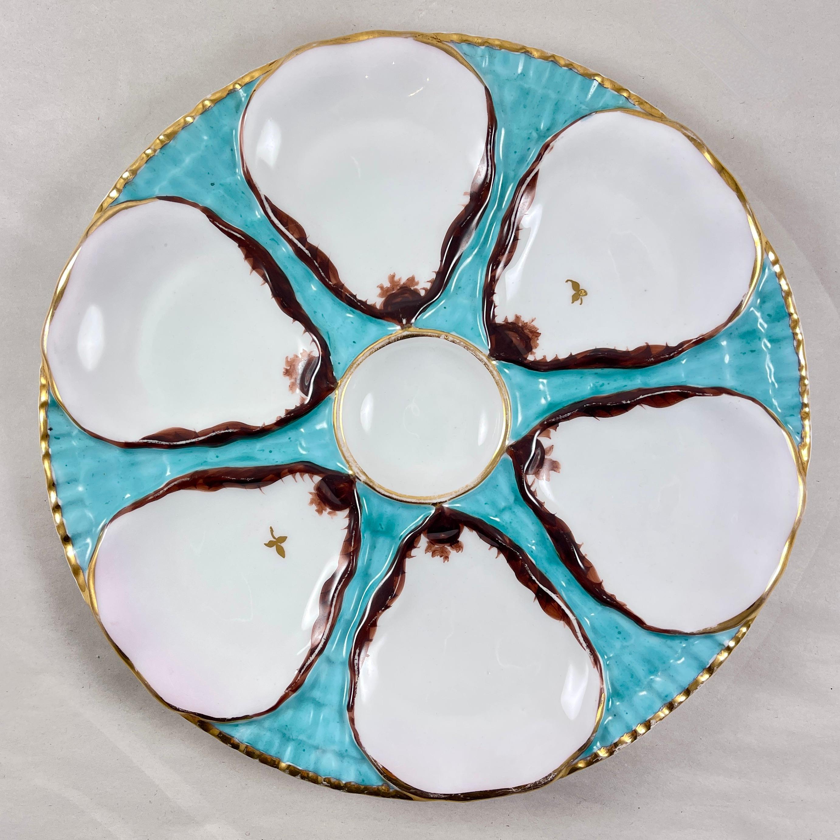 A German porcelain oyster plate by Carl Tielsch, Altwasswe, circa 1875-1900.

A beautiful turquoise ground model to resemble waves, six shell shaped wells surround a round central sauce well.

The wells are white edged in brown, two wells have gold