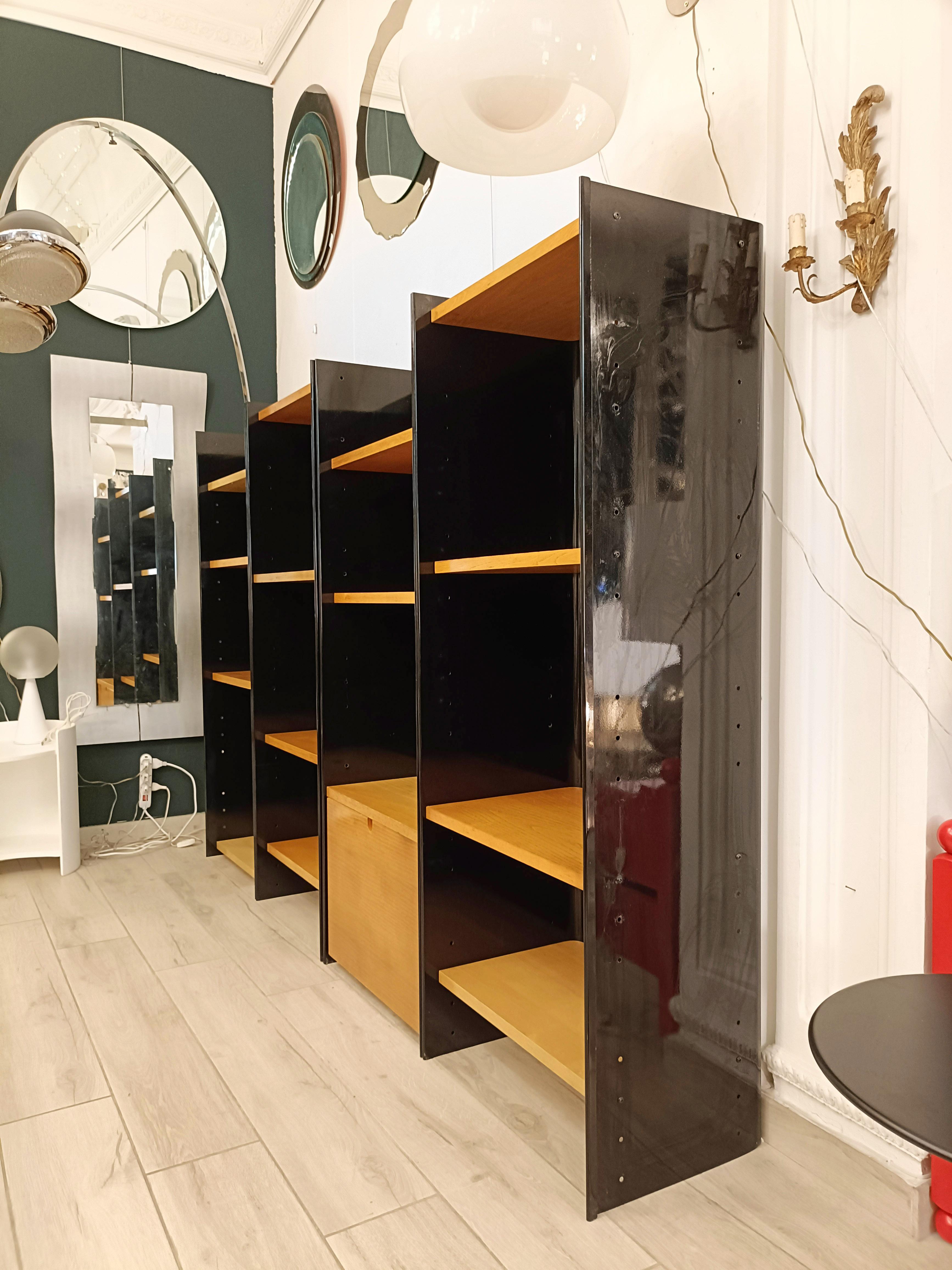 Bibliothèque autoportante moderne italienne conçue par Carla Venosta pour la société Arflex,  avec cadre métallique incurvé et émail noir brillant, avec étagères en bois massif et tiroir central sur roulettes. Bon état, quelques signes de