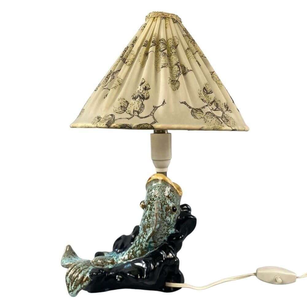 Rare midcentury ceramic table lamp by Carli Bauer from the 1950s. It is a unique piece of Carli Bauer's oriental series, which depicts a goldfish, unlike the known figurative figures.
A turquoise-beige fish built on a black base, with a lamp placed