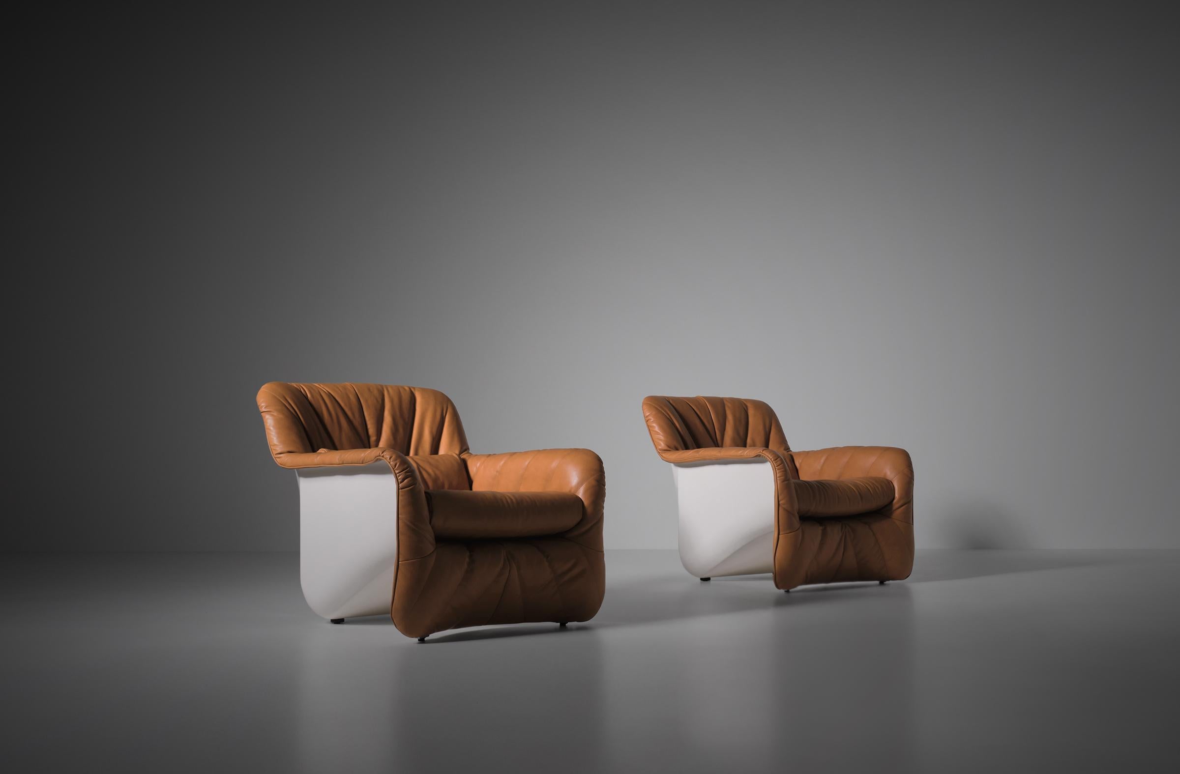 Carlo Bartoli 'Bicia' lounge chairs for Arflex, Italy, 1969. Stunning fiberglass shells with a soft cognac leather upholstery. Very interesting combination of the elegant design and radical use of material.
The leather upholstery is executed with