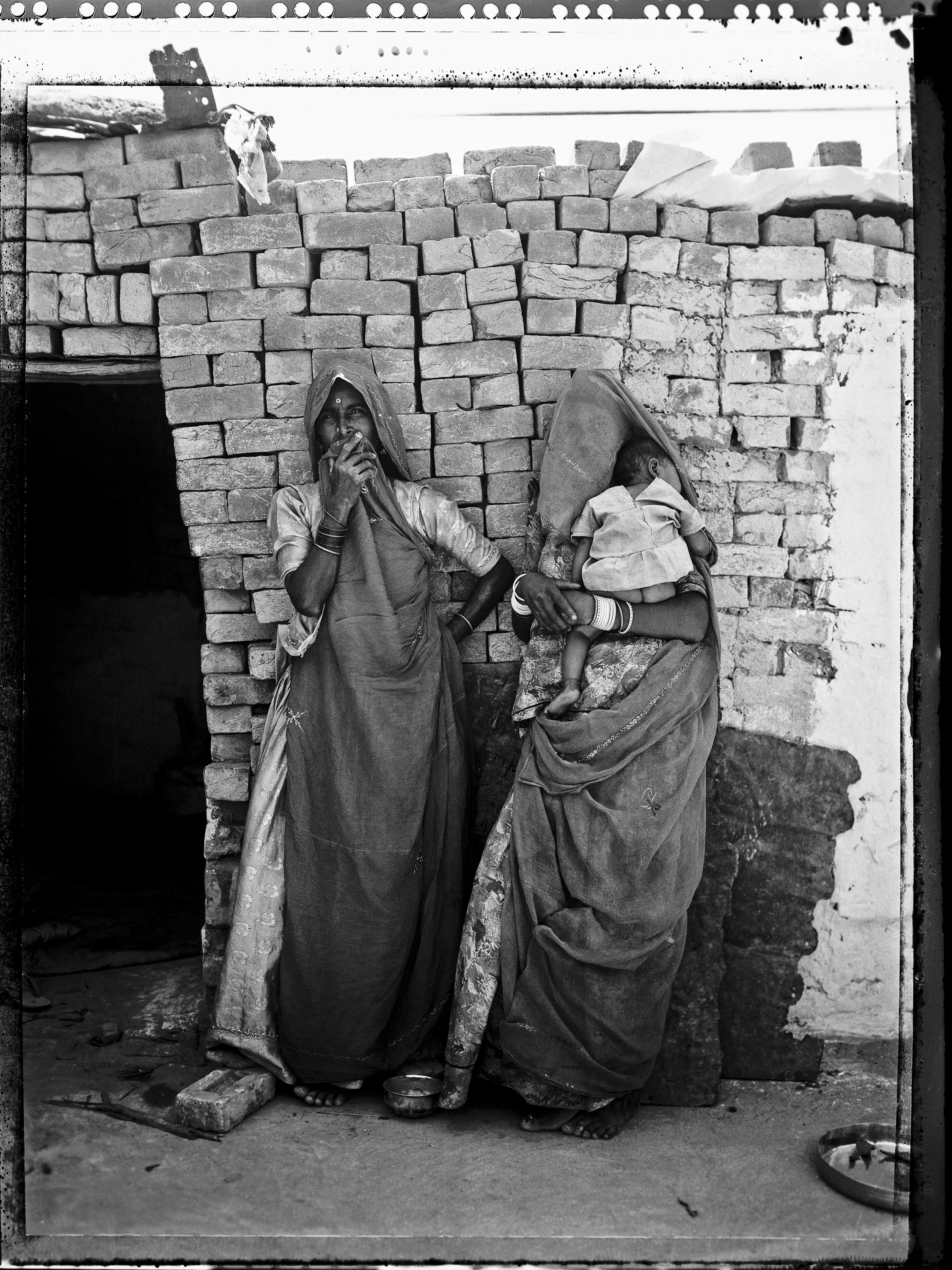 Carlo Bevilacqua Black and White Photograph – Indische Frau in einer Güterwohnung mit Kind – Rajastan – Indien