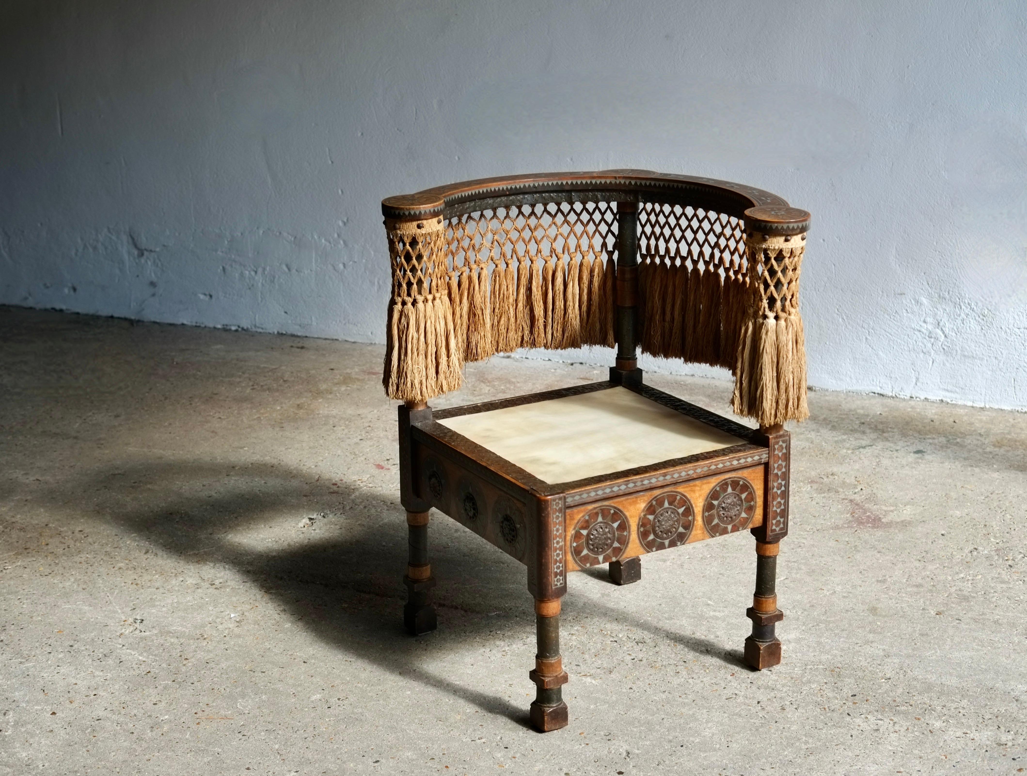 A stunning corner chair by Italian designer Carlo Bugatti (1856-1940), circa 1890's, Milan, Italy. 

Walnut and stained maple wood frame, pewter inlays, hand-hammered wrought copper appliques and legs wrappers, original silk tassel fringes, natural