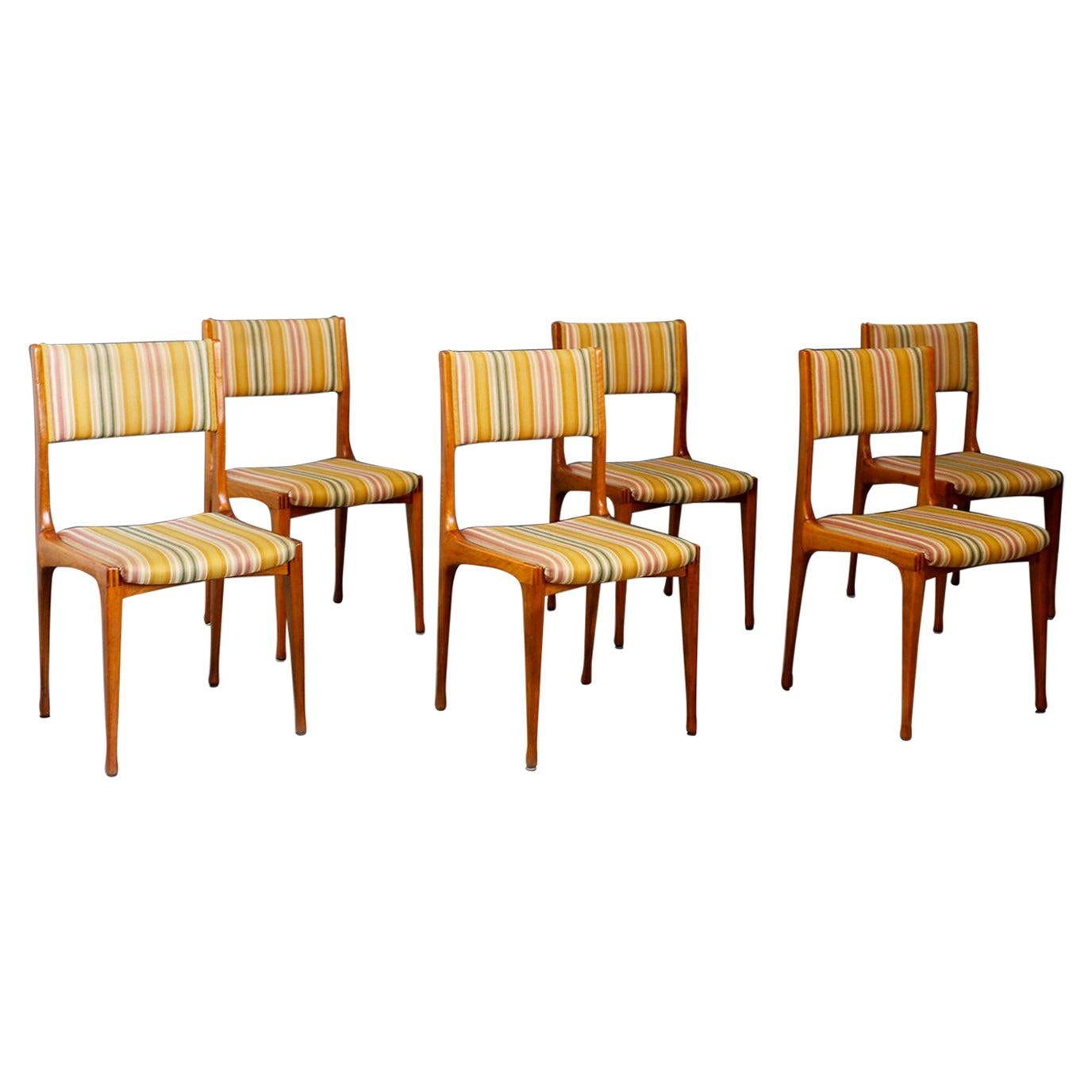 Six chairs designed by Carlo de Carli for the Cassina factory in 1950. The chairs are model 693. They are made with wooden frame and original fabric of the time in excellent condition. The chairs are in excellent condition and are ideal to furnish