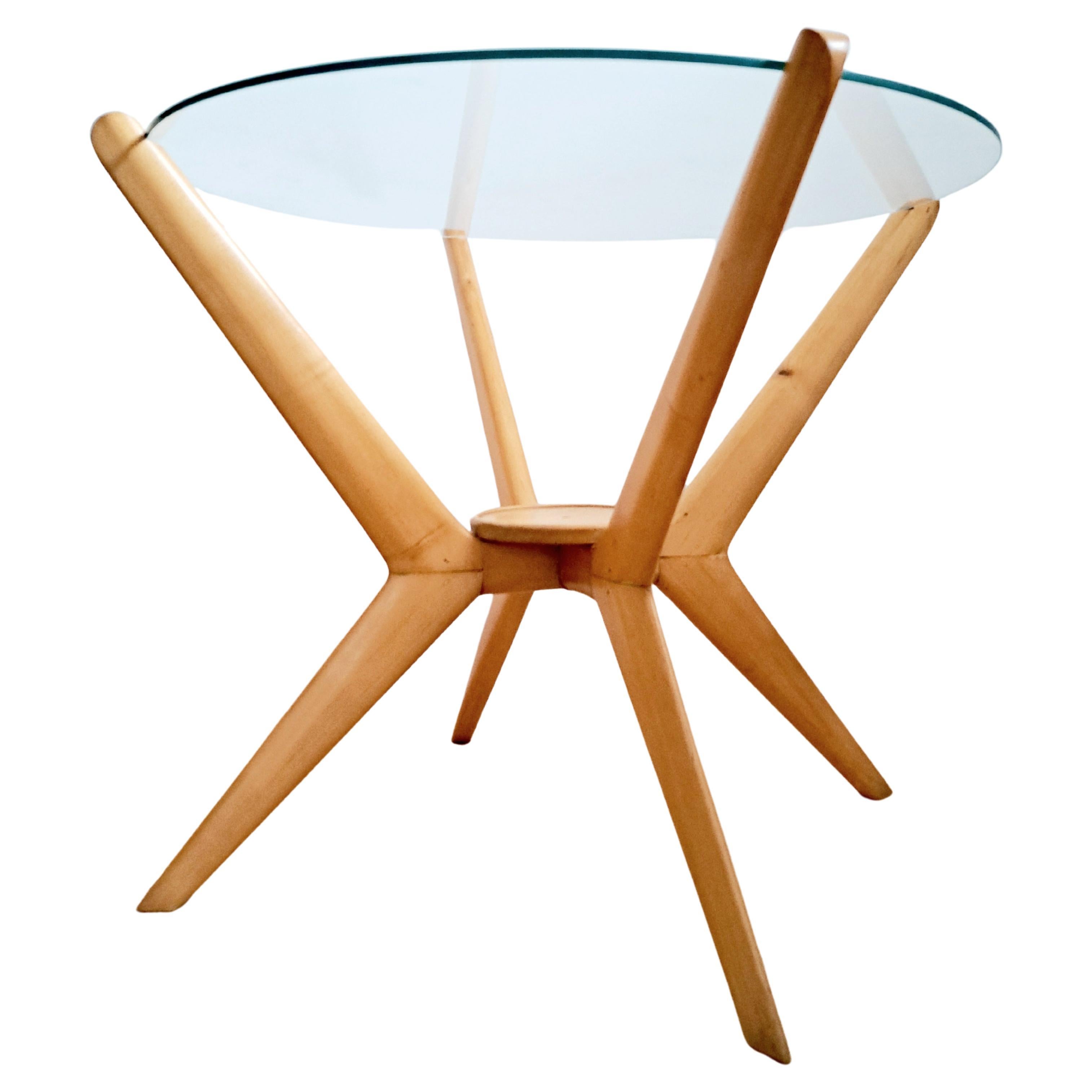 An elegant modernist coffee table/side table with lovely spider-type legs. 
Made of beech wood with a glass top. Made in Italy in the 1950s, by Calo di Carli. In good condition for age, with some slight scratches and cuffs on the wooden legs. New