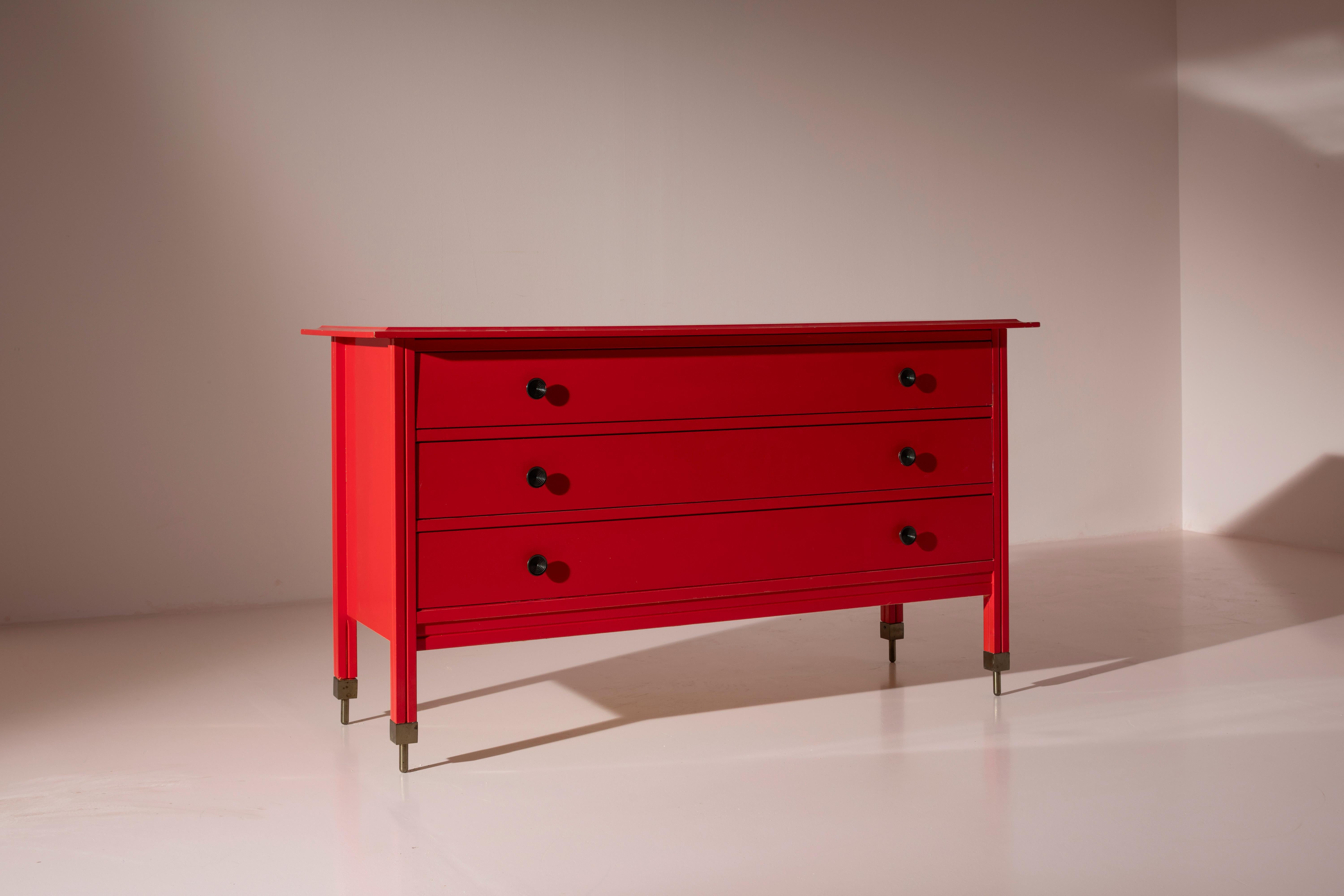A chest of drawers, model D154, in painted wood with brass cast elements, designed by Carlo de Carli, manufactured by Sormani, Italy, 1963. The intense red color characterizes this three-drawer piece designed by Carlo de Carli.

A true symbol of