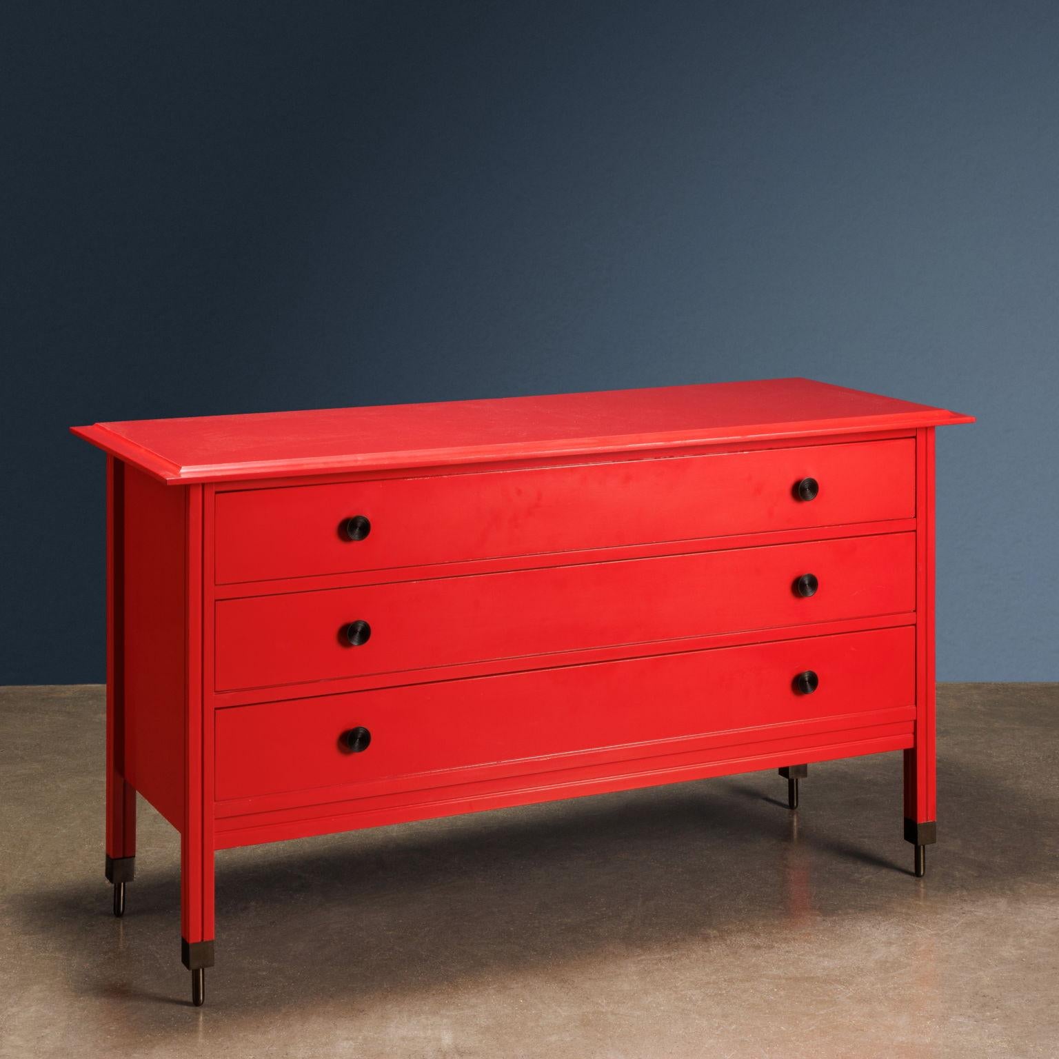 Red lacquered wooden chest of drawers model 'DC 154' with brass tips and handles; designed by Carlo de Carli and produced by Sormani from 1963-64.