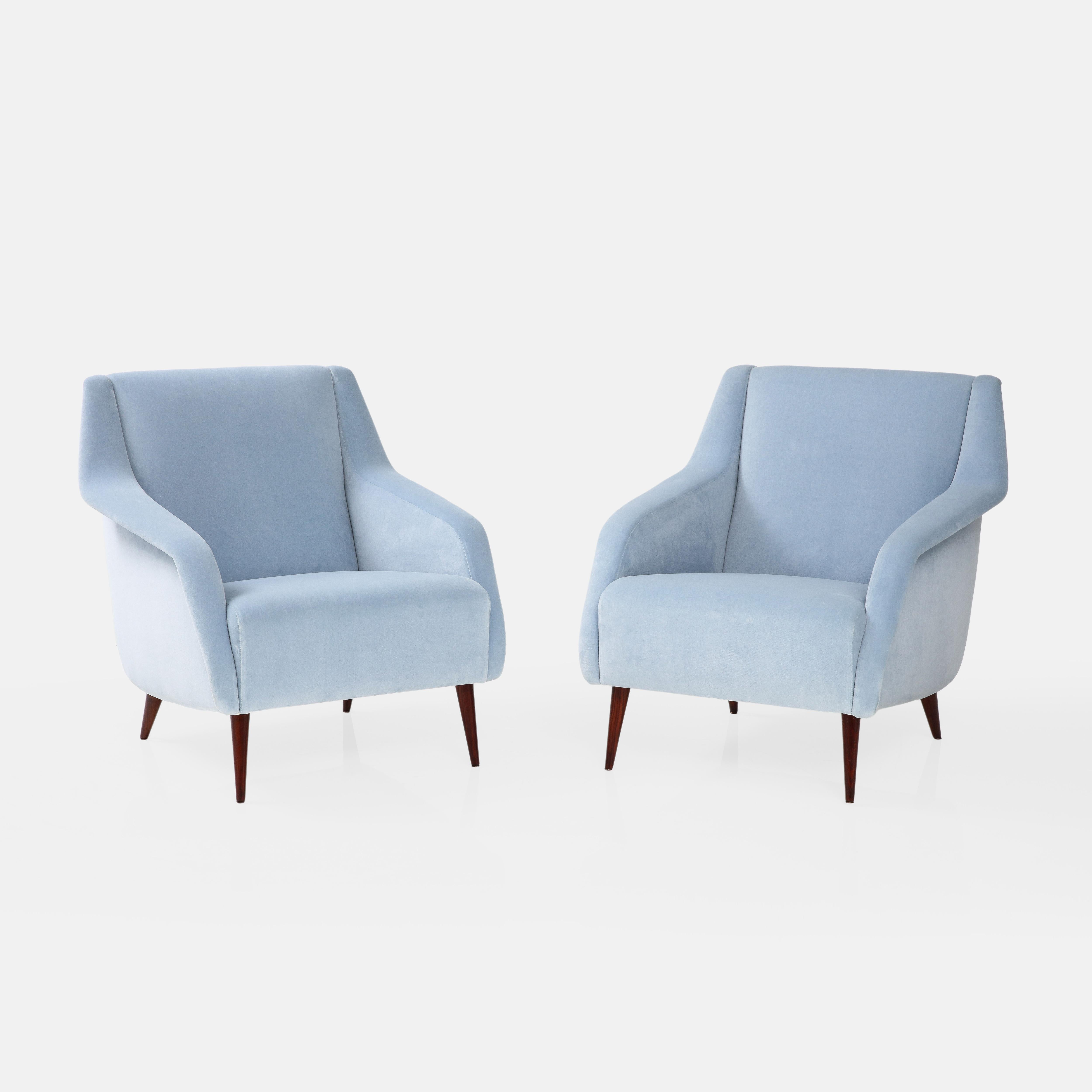 Carlo De Carli pour Cassina paire de chaises ou fauteuils de salon sculpturaux en tapisserie de velours bleu clair avec pieds en bois teinté. Ces fauteuils sont un modèle emblématique de la première édition de Carlo De Carli, avec des lignes
