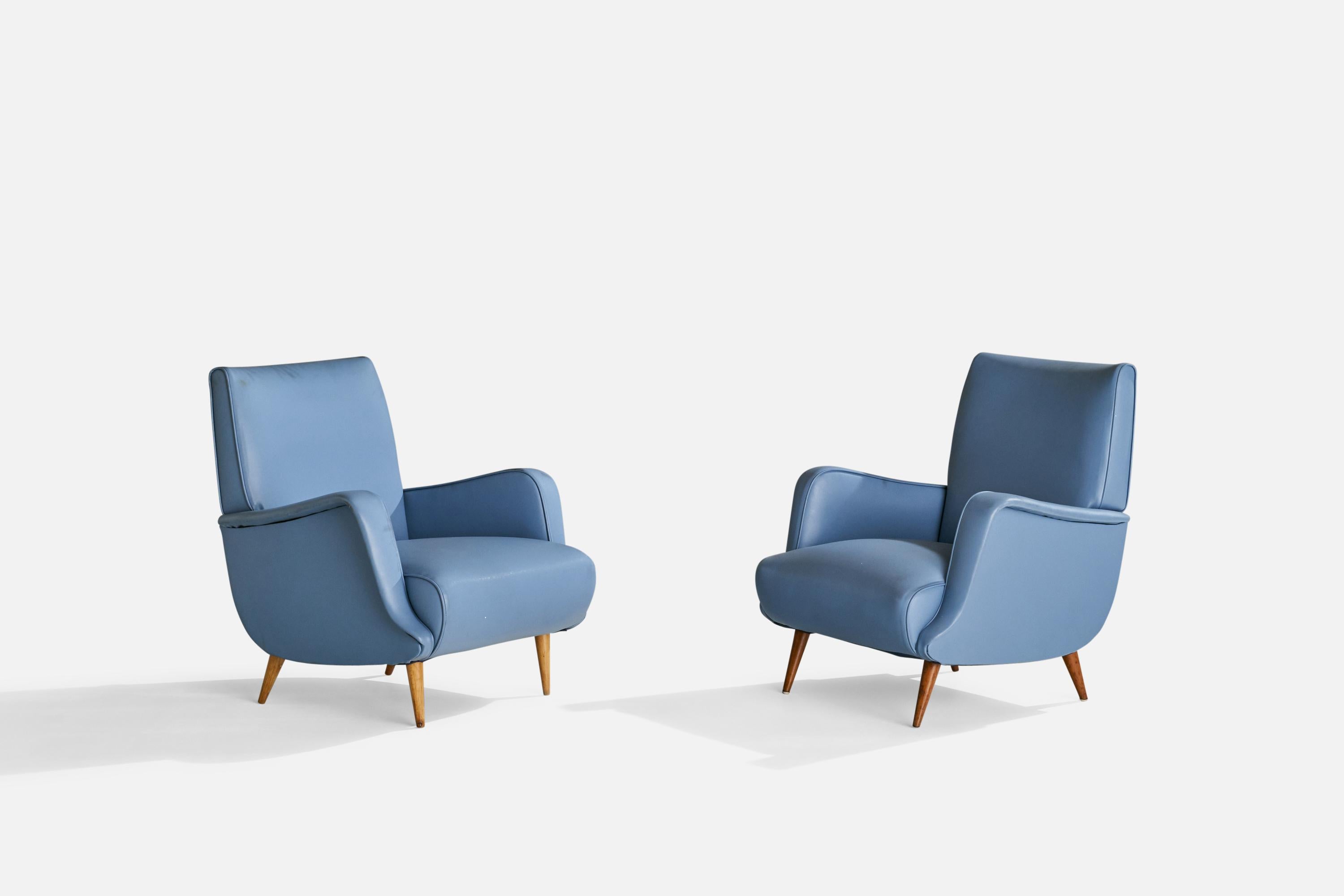 A pair of blue vinyl and wood lounge chairs designed by Carlo De Carli, Italy, c. 1960s.

Seat height 15”.