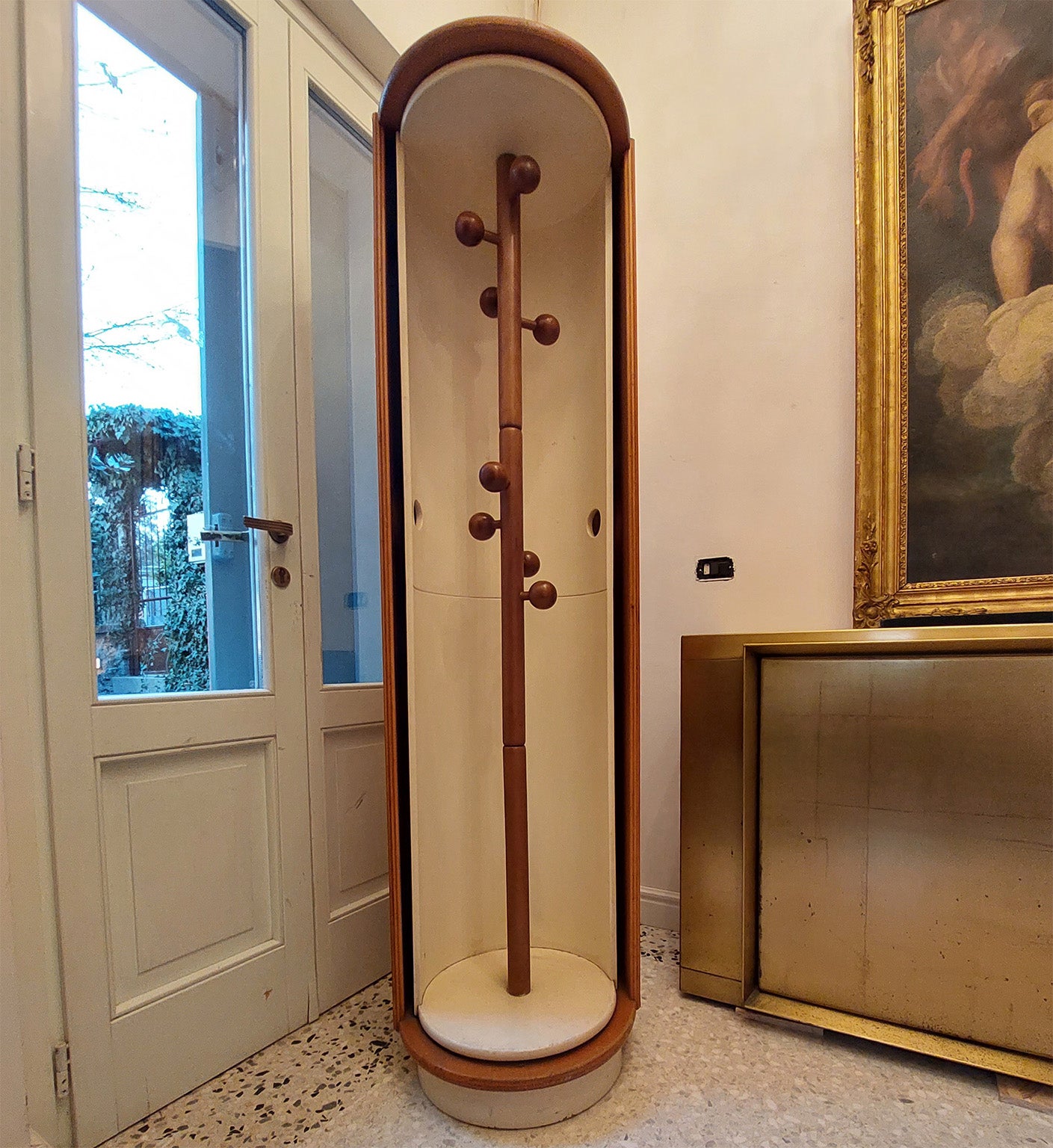 Elegant circular rotating coat rack cabinet, designed by Carlo de Carli in 1970 circa. 
Provenance from a Milano house. 
The round rotating curved door in wood white lacquered envlops a central solid wood pole supports multiple hanging balls.
The