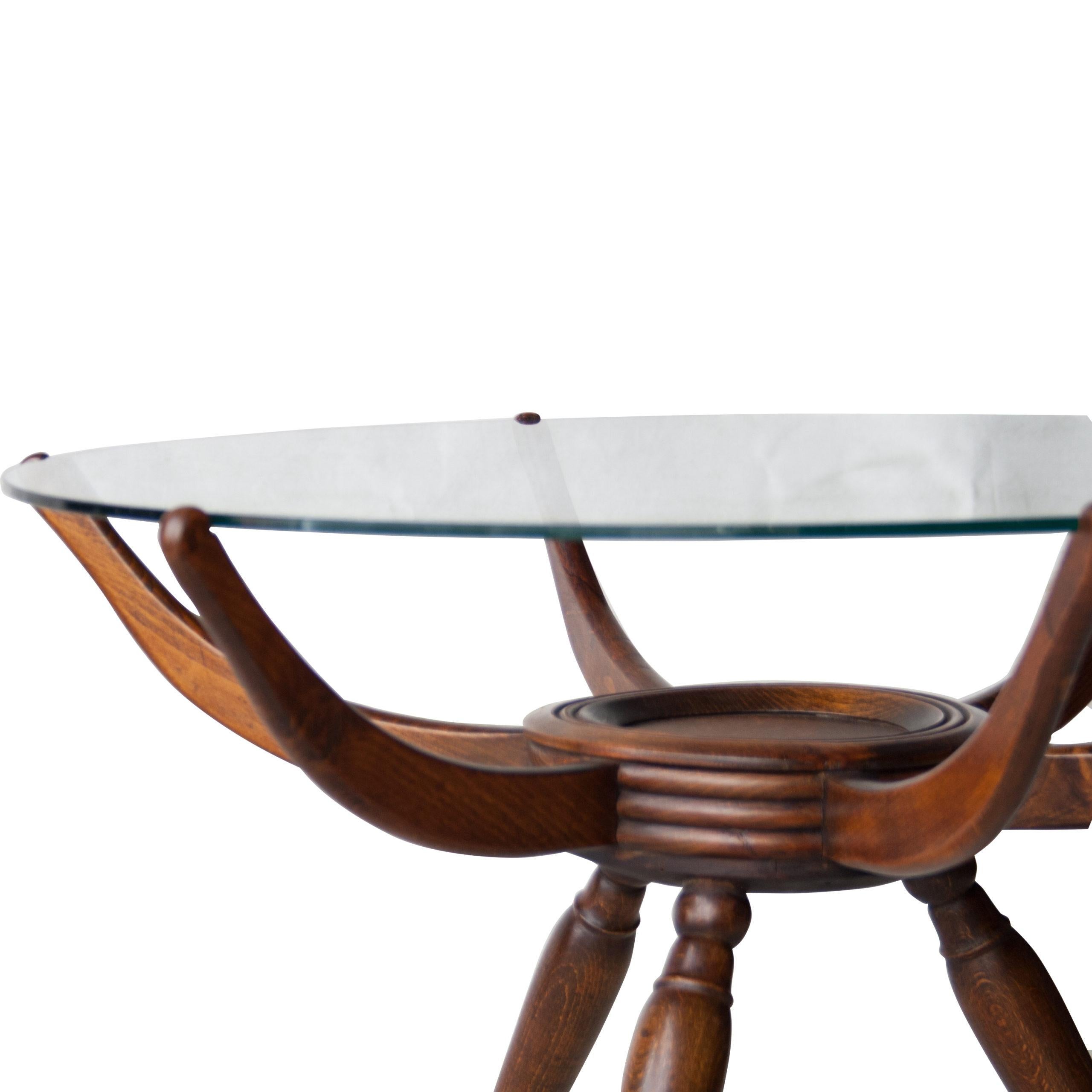 Italian spider table designed by Carlo de Carli in the 1950s. Mahogany three legged structure with rounded glass top.
 