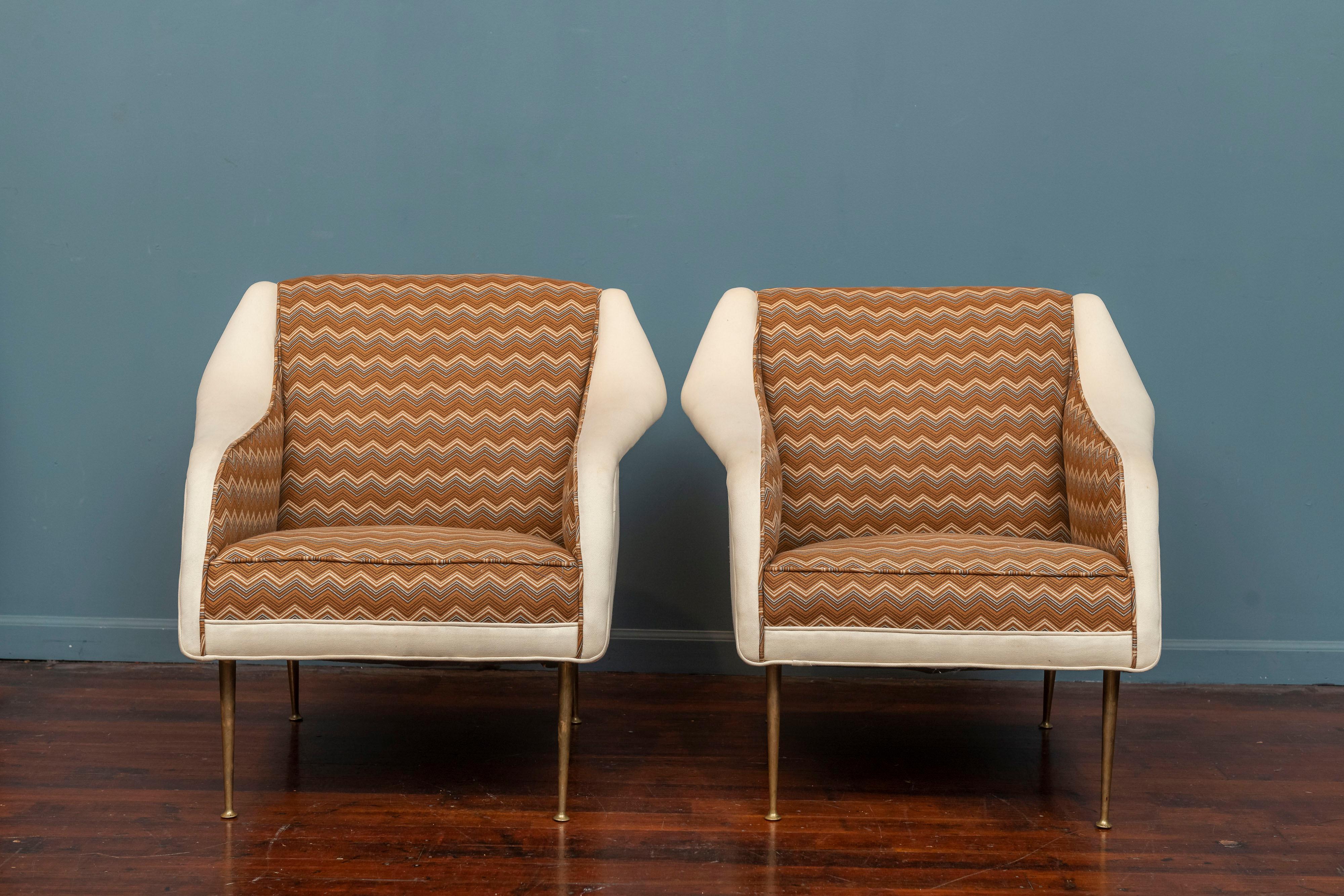 Carlo de Carli design lounge chairs for M.Singer & Sons, Model 802. Sophisticated looking chairs with stiletto brass legs and curvaceous arms that is beautiful from all angles. The fabric is an older redo that is usable as-is and very comfortable