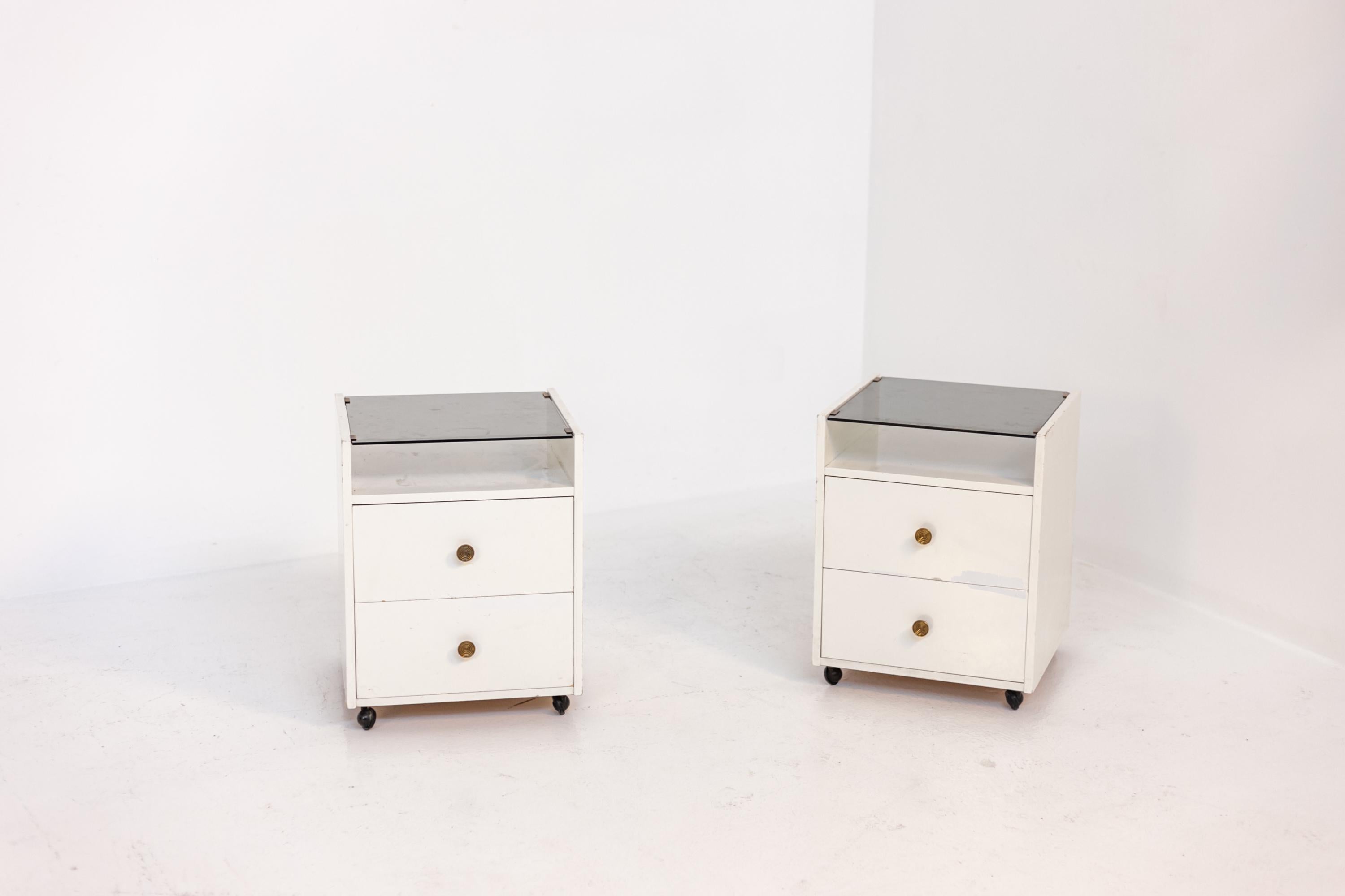 Elegant pair of Italian nightstands made by designer Carlo de Carli for the Sormani manufacture in the 1960s. The furniture is easily transportable via their four rolling feet. The nightstands are made with a white wood frame. The nightstands