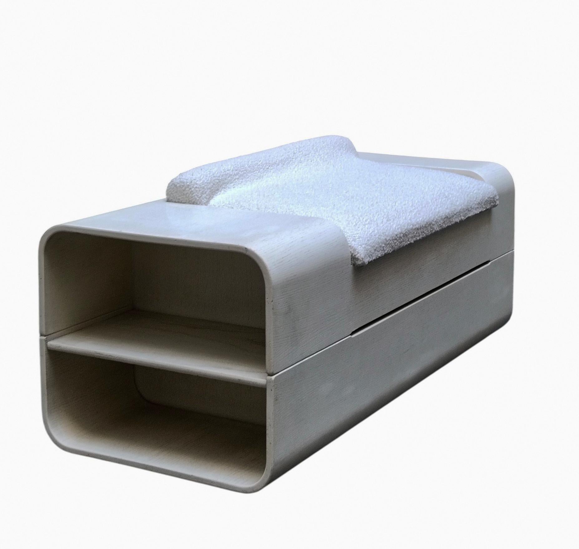 Panca in legno disegnata da Carlo De Carli per la Ditta Italiana Fiarm, la panca e' in legno tinto bianco, con cuscino tessuto boucle' bianco, la seduta si apre e diventa un vano contenitore, ai due lati un portariviste ed un vano x oggetti.