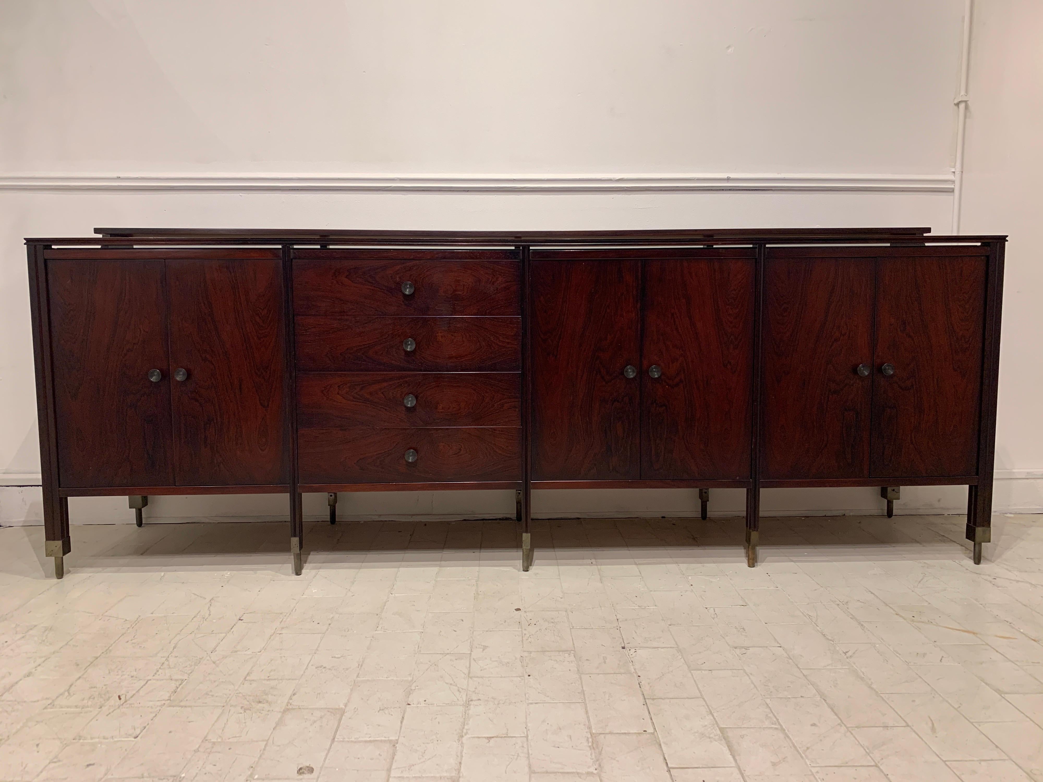 This sideboard is designed by Carlo de Carli and executed by Sormani in 1964 from D154 series. The doors and drawers are veneered. Feet and handles are in brass. On the top rests a black glass top.

 