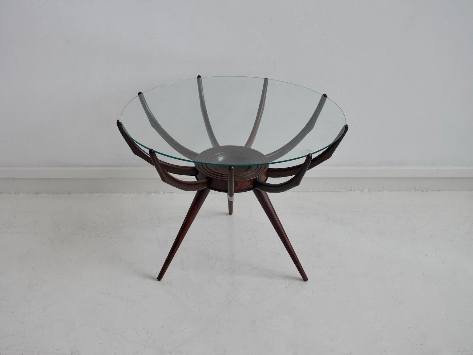 Coffee table with wooden base and round transparent glass top made in Italy. The form of the table is derived and adapted from a Carlo De Carli 1942 table design.