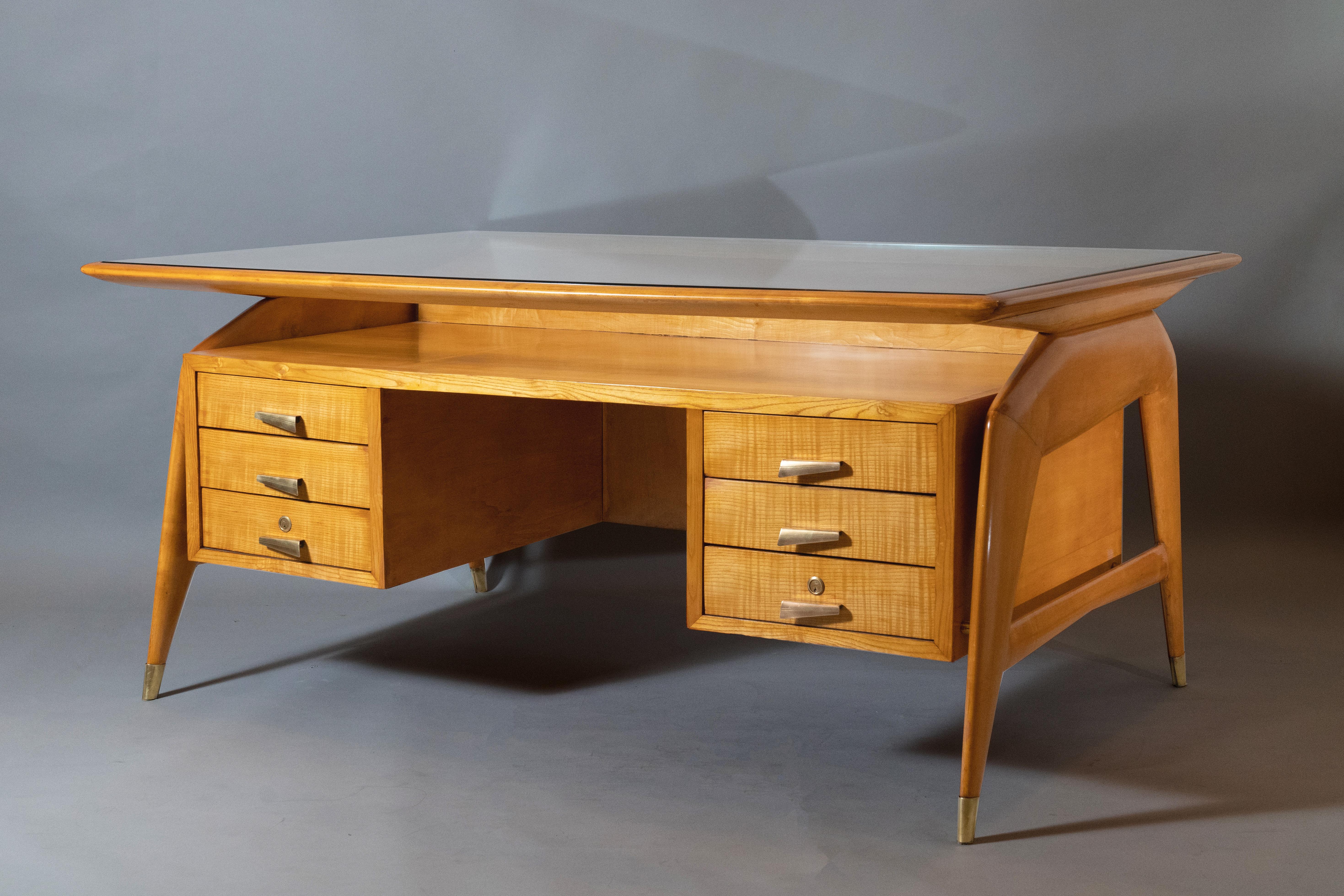 Carlo de Carli (1910 - 1999)
 
An important sculptural desk with six drawers by seminal Milanese architect and theorist Carlo de Carli, in fruitwood with polished brass handles and sabots. The floating top, fit with a rectangular glass insert that