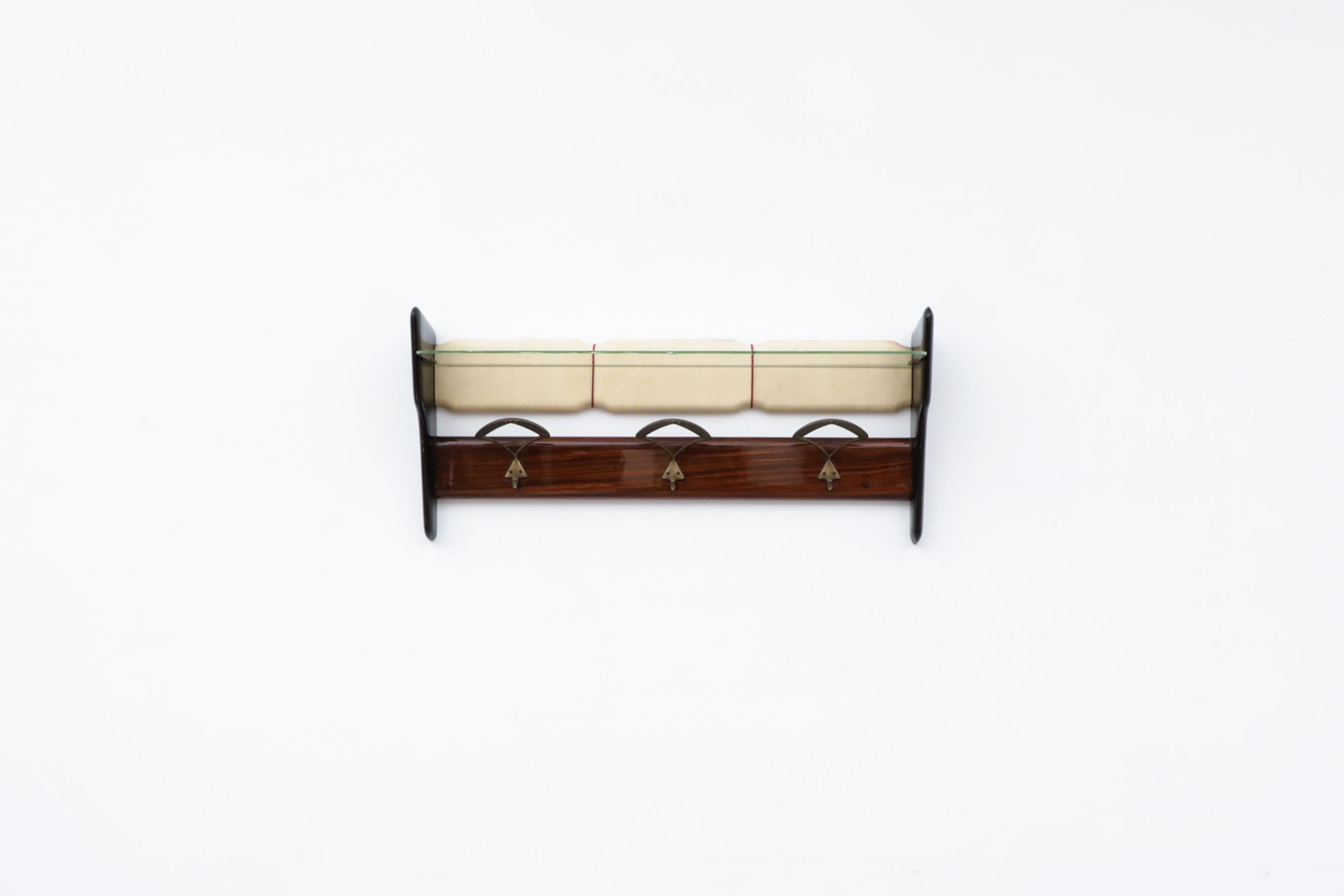 Carlo De Carli wall mounted coat rack with original glass shelf. In original condition with visible wear including a chip in the original glass shelf. Wear is consistent with its age and use.