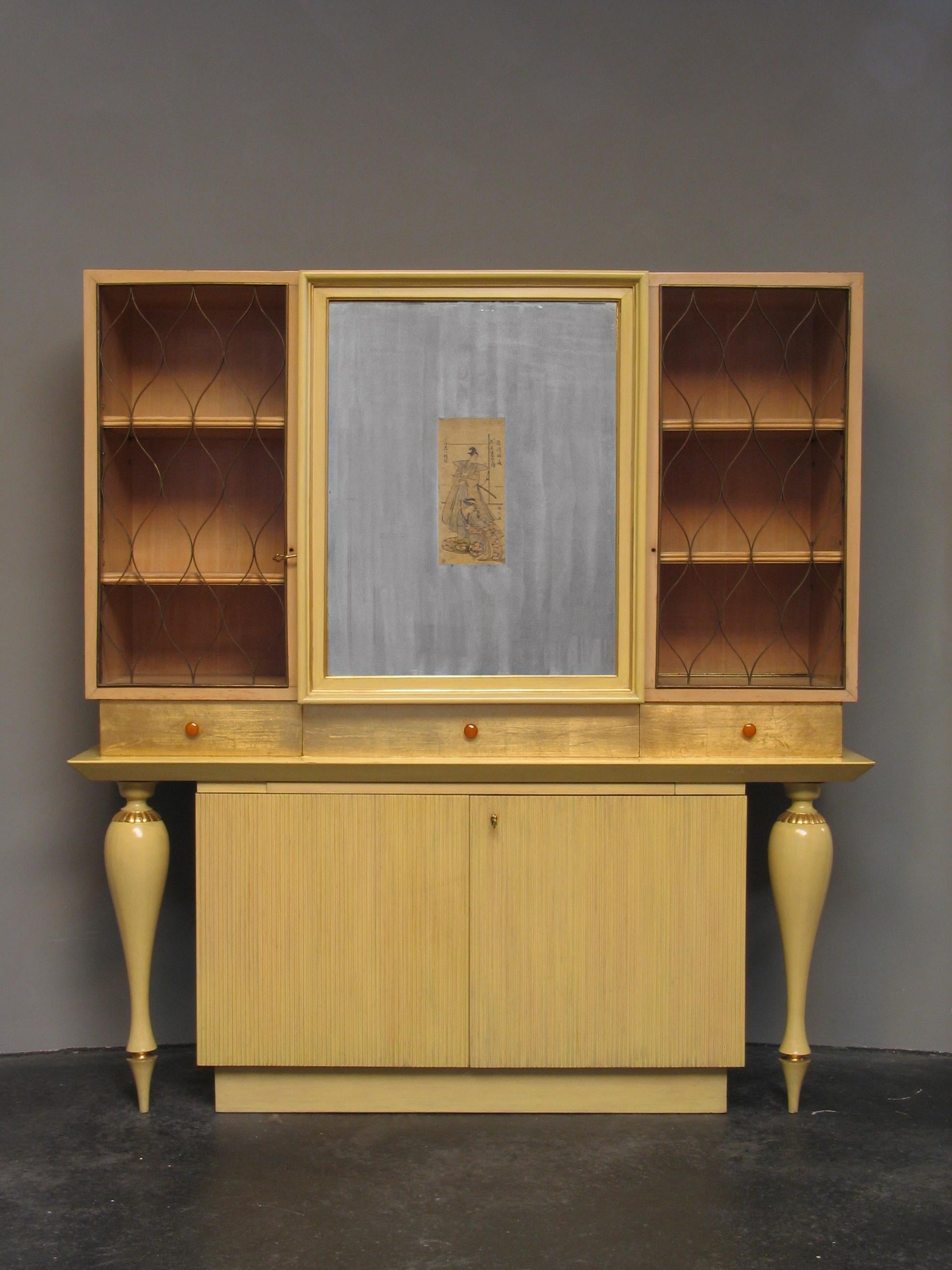 Zweiteiliger Esszimmer-Schrank
Carlo Enrico Rava
Milan
1940s
Geschnitztes und furniertes Ahornholz mit teilweise vergoldeten Messingtüren.
In der Mitte befindet sich eine verspiegelte Fläche mit einem Holzschnitt von Utagawa Kunimasa aus der