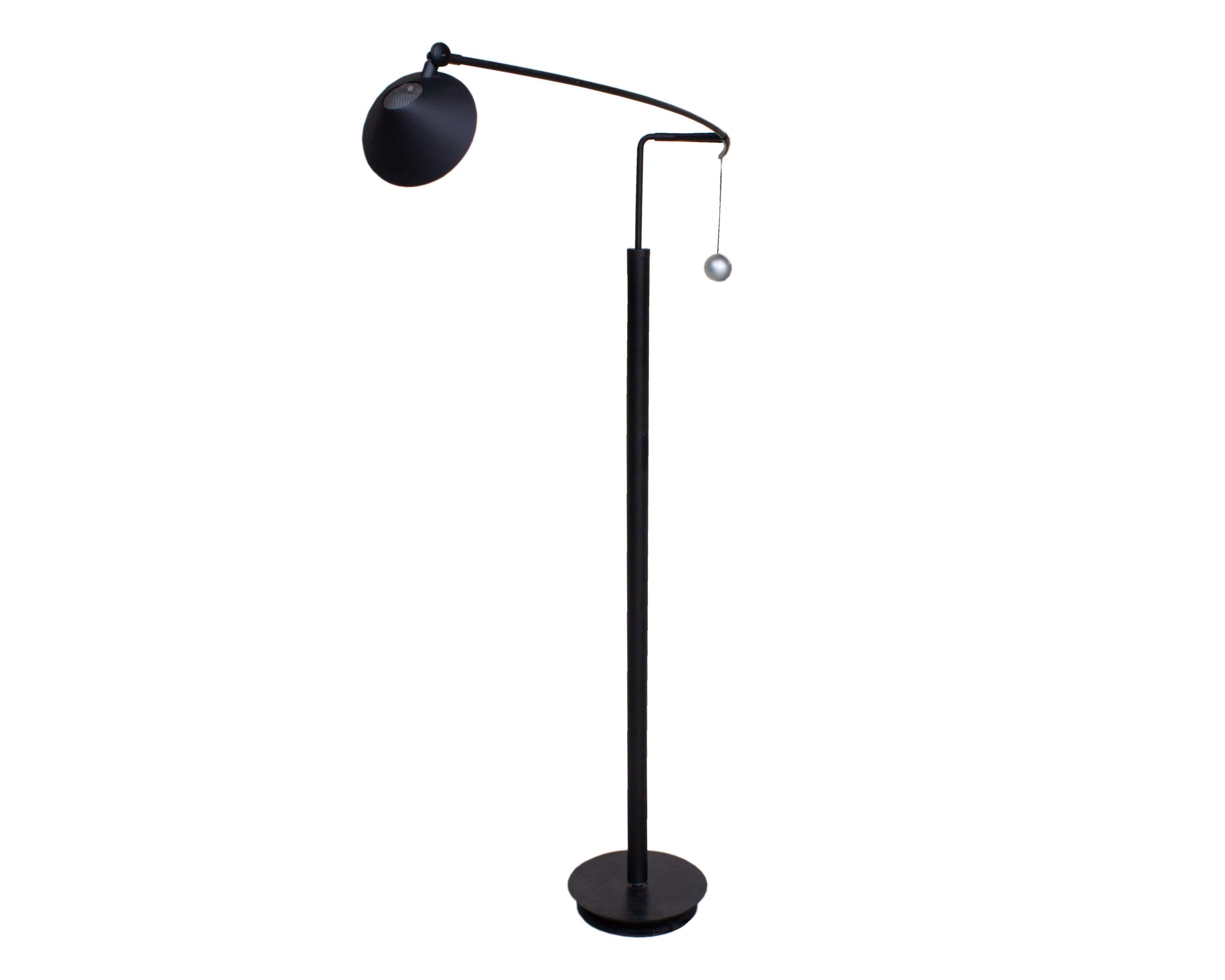 A Postmodern Nestore Lettura cantilever table lamp designed by Italian designer Carlo Forcolini (born 1947) for Artemide. Designed in 1989, the black matte lamp features a round, moveable plastic shade that covers a single socket. The shade is