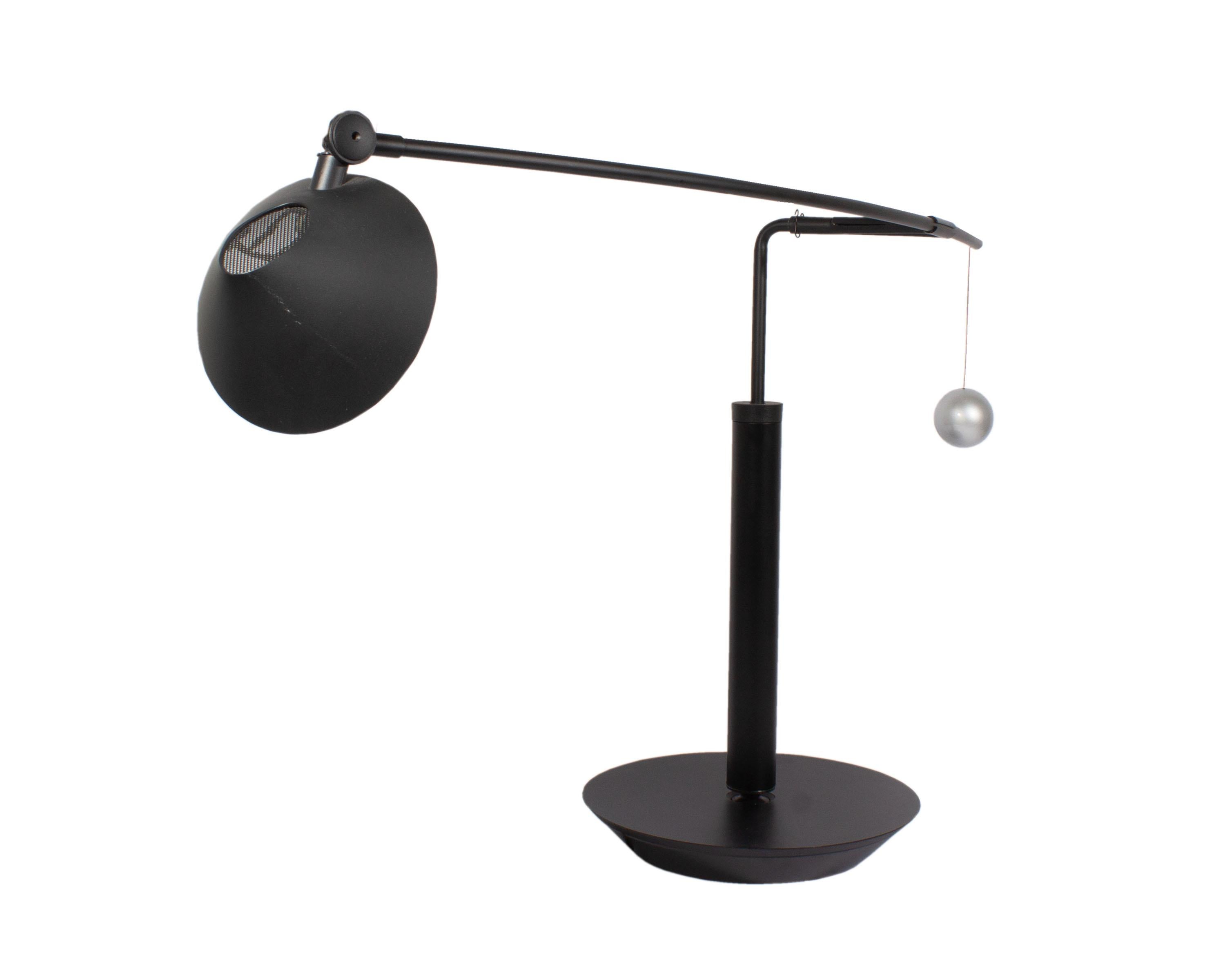A Postmodern Nestore Lettura cantilever table lamp designed by Italian designer Carlo Forcolini (born 1947) for Artemide. Designed in 1989, the black matte lamp features a round, moveable plastic shade that covers a single socket. The shade is