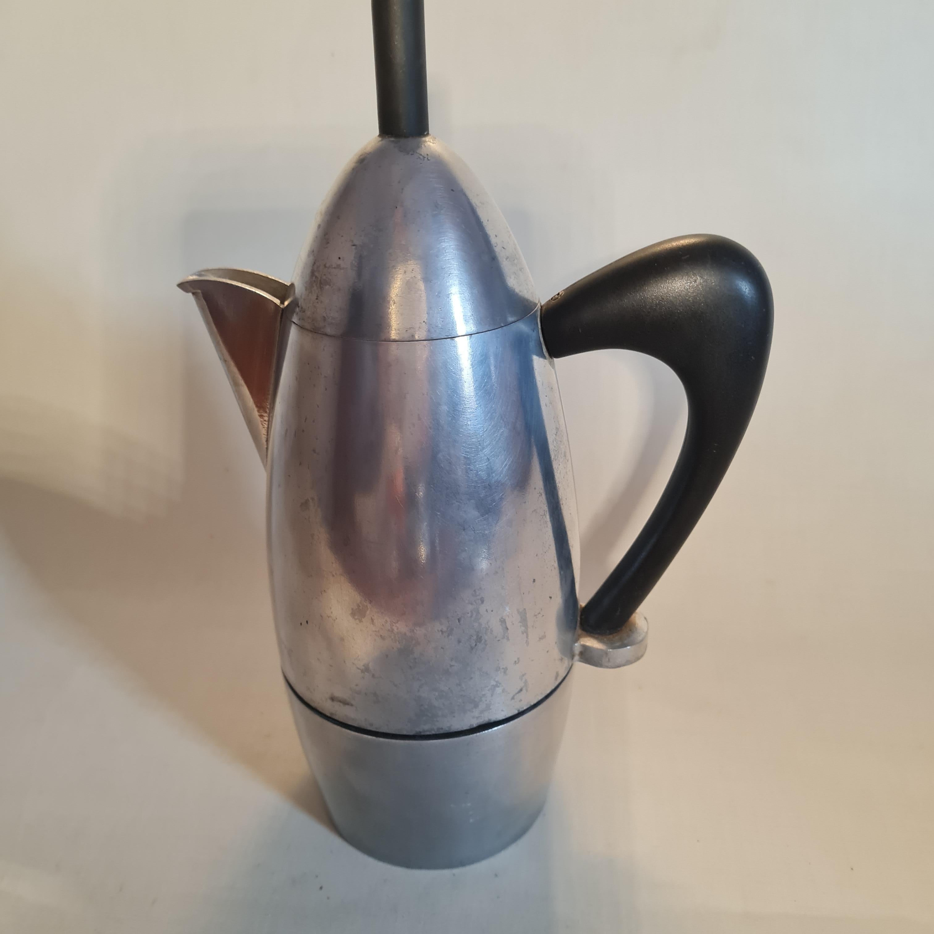 A Carlo Giannini, Italy, espresso maker, the bullet shaped aluminium body with black plastic handle and tall cylindrical finial, 26cm high