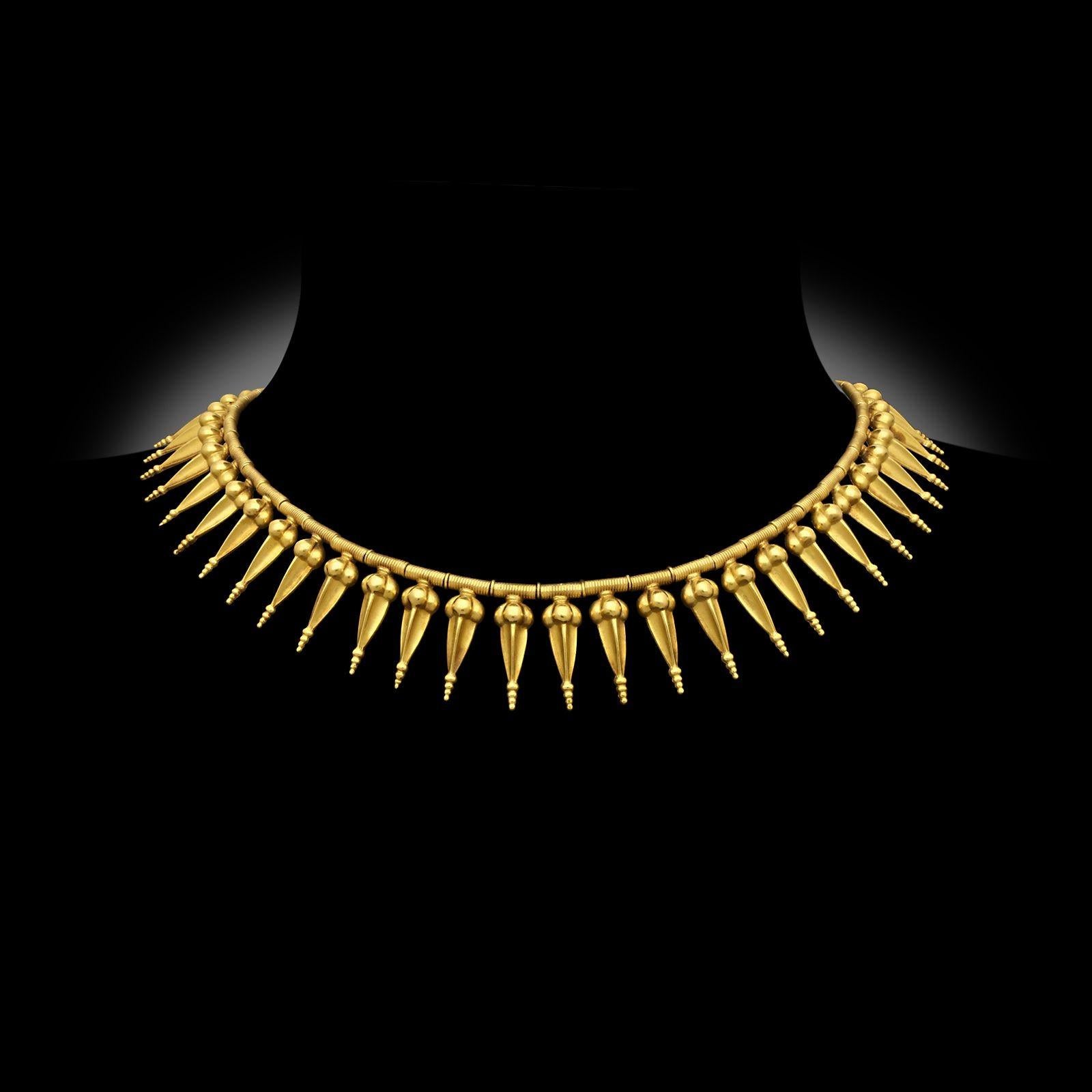 Collier antique à franges en or de style néo-archéologique, réalisé par Carlo Giuliano vers 1880. Ce collier est composé d'une série de pendentifs stylisés en forme de Cicada, avec des terminaisons perlées, suspendus à des bobines d'or sur la chaîne