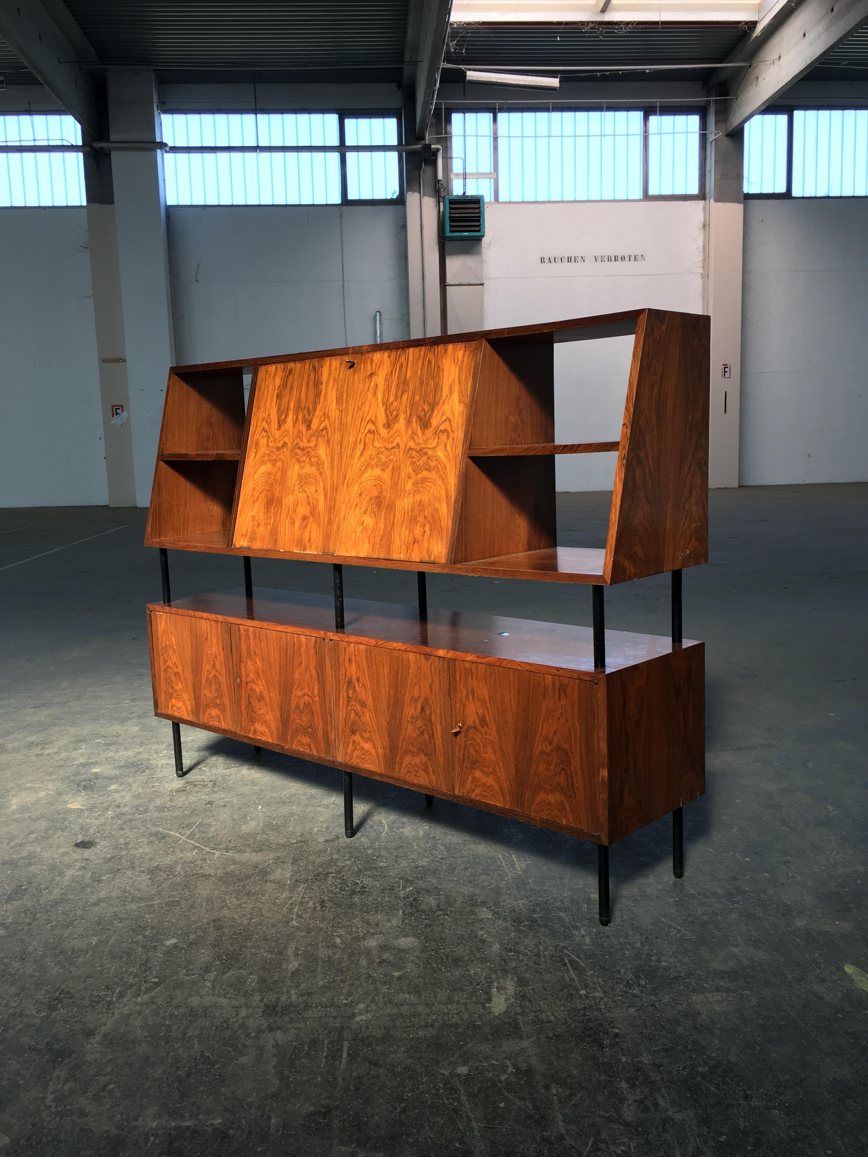This bookshelf with bar cabinet is a rare and elegant piece designed by Carlo Hauner and Martin Eisler in Brazil 1955. 

The stunning piece presents several storage compartments, with four cabinets in the bottom, niches, and a spacious bar cabinet